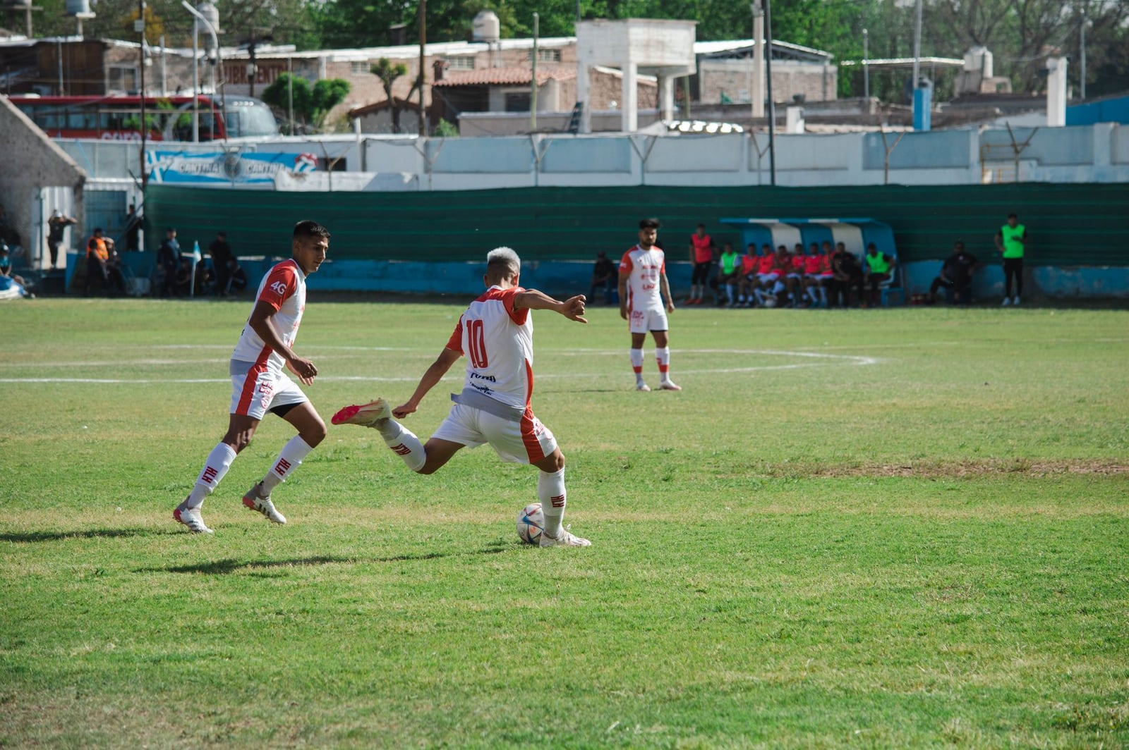 Juego intenso de fútbol en Mina, Mendoza, Argentina, que muestra trabajo en equipo y acción en un día soleado.