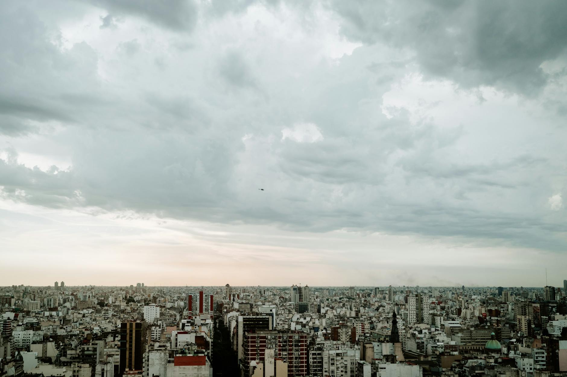 Una vista aérea panorámica del horizonte de Buenos Aires bajo un cielo nublado, enfatizando la densidad urbana.