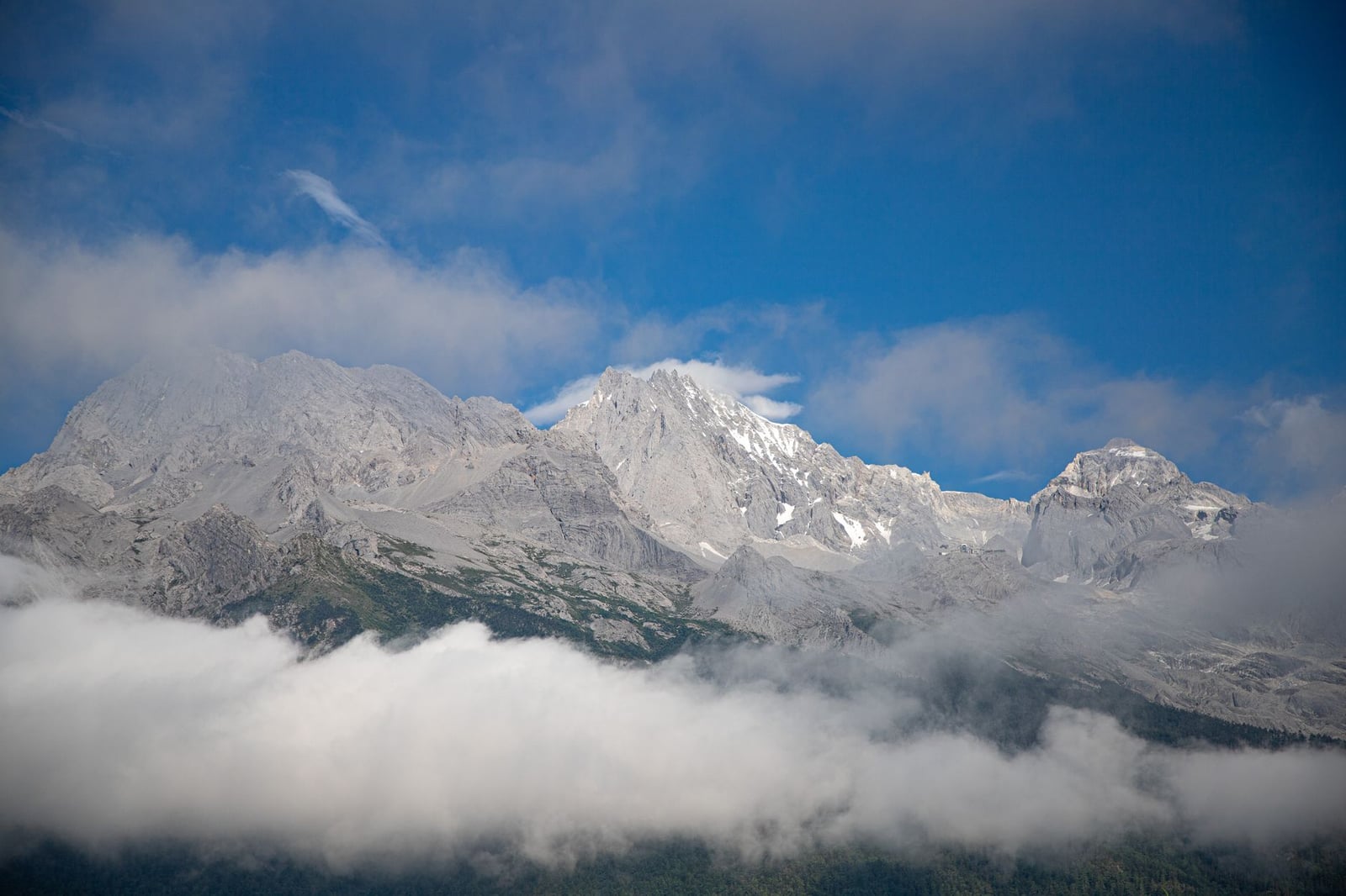 Impresionante vista de la Montaña de Dragón de Jade con nubes y cielo azul en Lijiang, China.