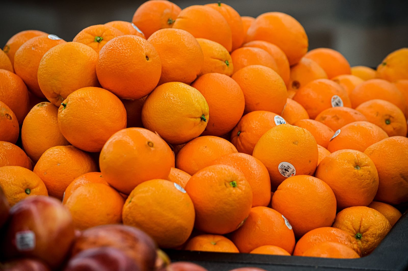 Naranjas de colores vivos apiladas en un mercado que muestra frescura y abundancia.