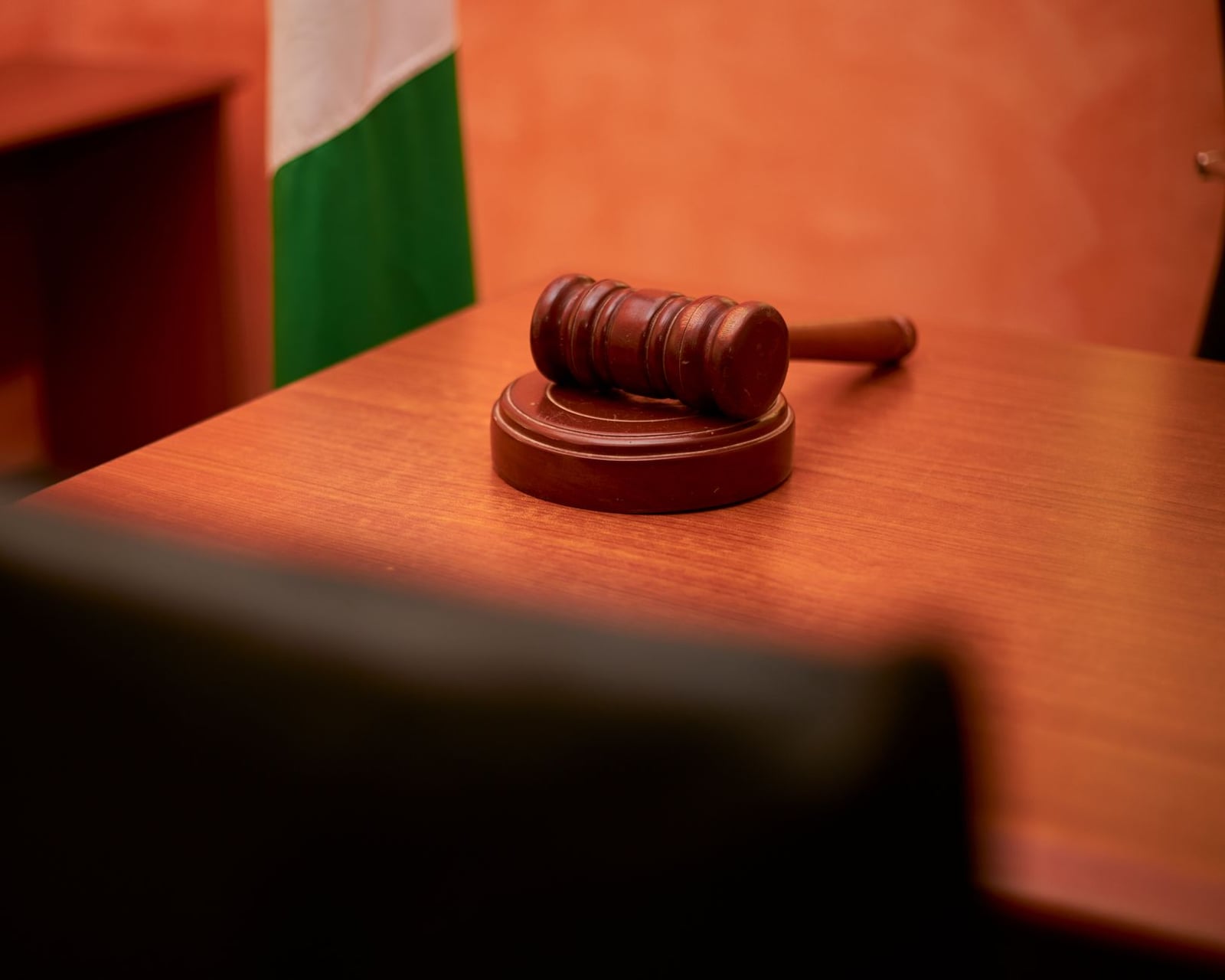 Un primer plano de un mazo sobre el escritorio de un tribunal, que representa la ley y la justicia.