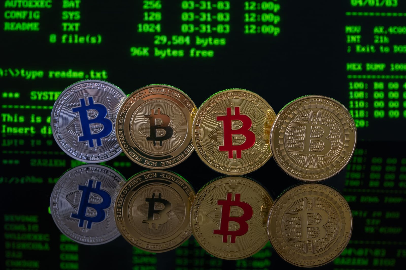 Imagen de monedas de Bitcoin reflejadas en una superficie sobre un fondo de código digital, que representa las criptomonedas y los mercados digitales.