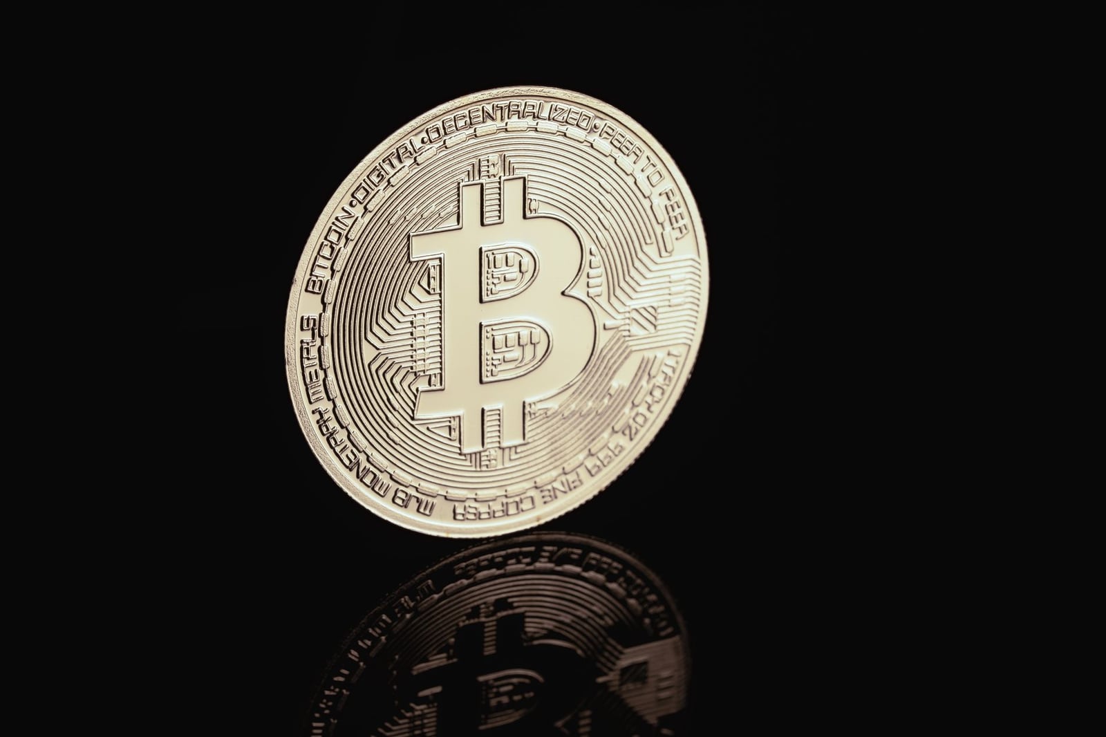 Primer plano de una moneda Bitcoin dorada, centrándose en temas de criptomonedas y finanzas digitales.
