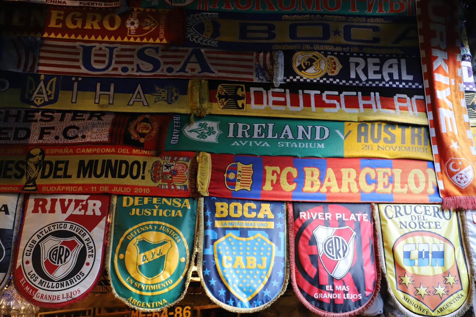 Una vibrante variedad de bufandas de aficionados al fútbol internacional que muestran varios equipos.