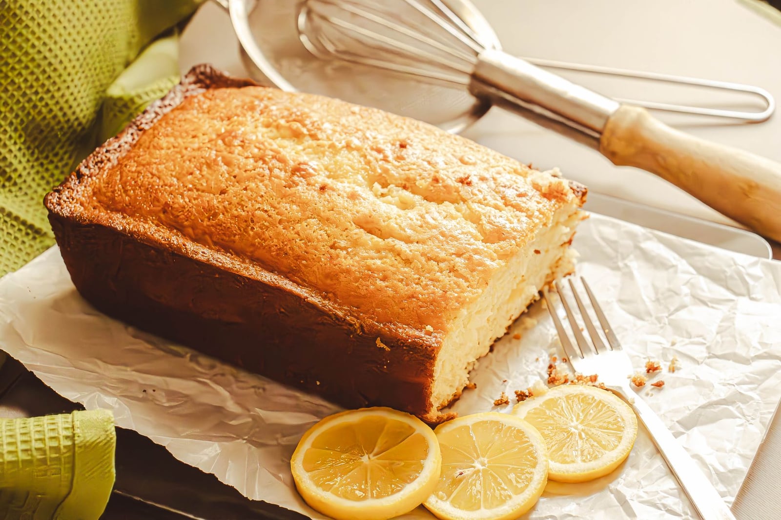 Un delicioso pastel de limón casero acompañado de rodajas de limón fresco, perfecto para los amantes del postre.