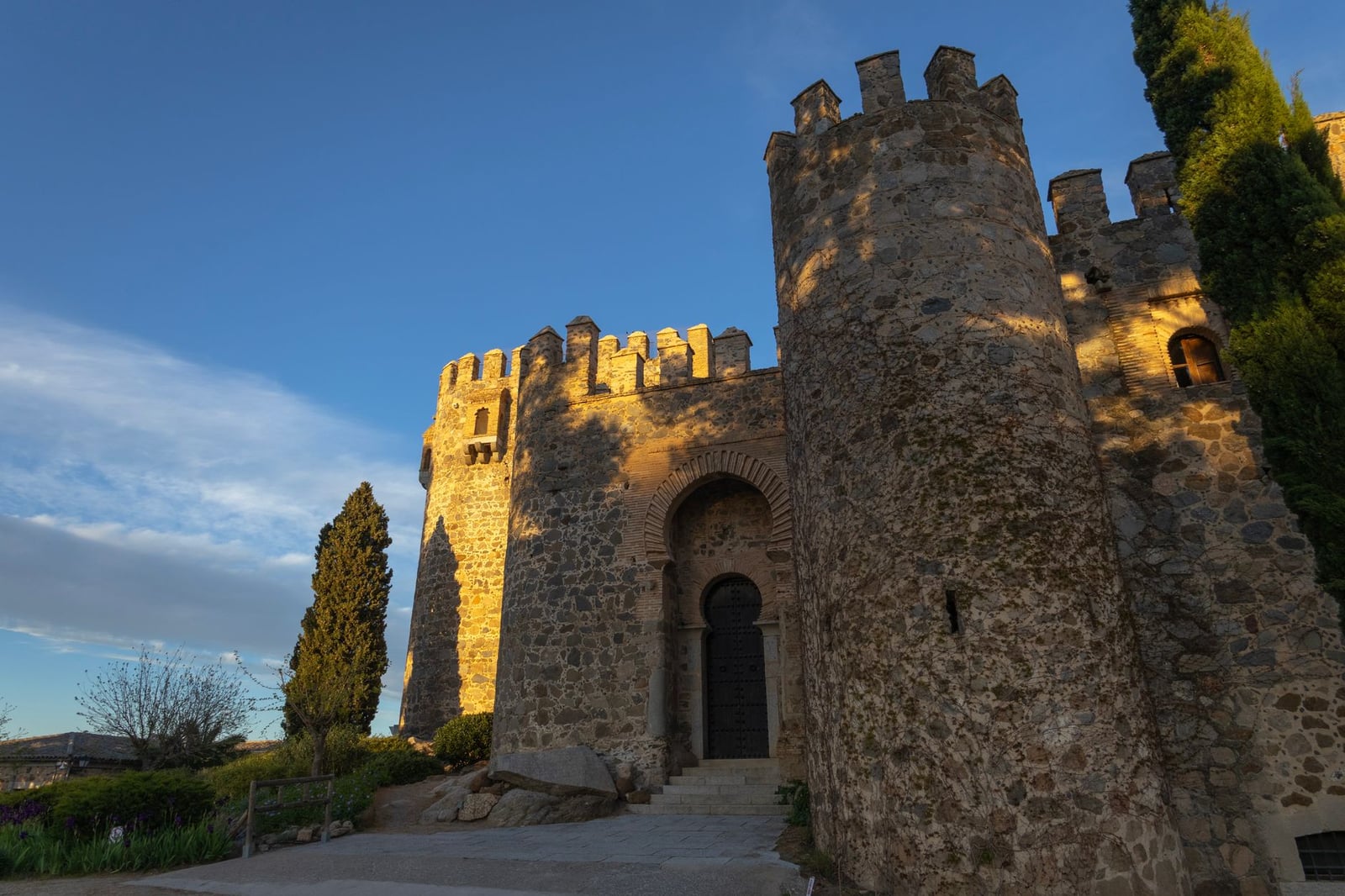 Majestuoso castillo de piedra en Toledo, España, bañado en luz dorada del atardecer que resalta su antigua arquitectura.