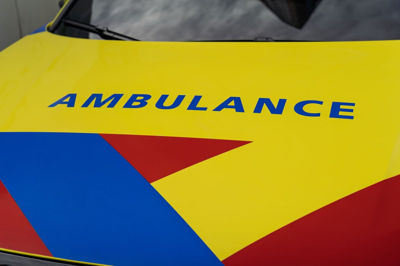 Vista detallada del colorido diseño de la capota de una ambulancia, que muestra colores primarios y texto en negrita.