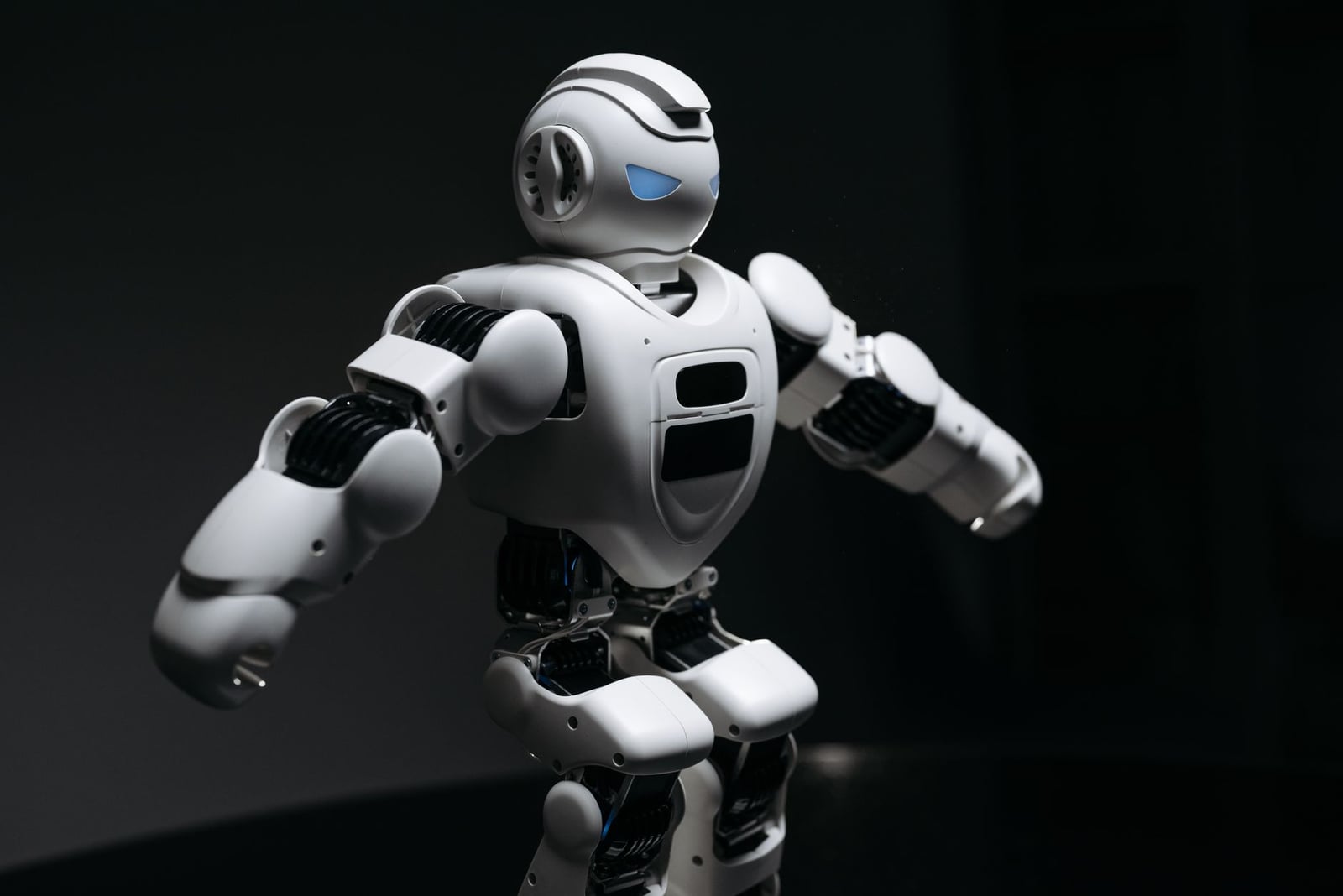 Primer plano de un robot humanoide futurista bajo una iluminación dramática en una atmósfera oscura.