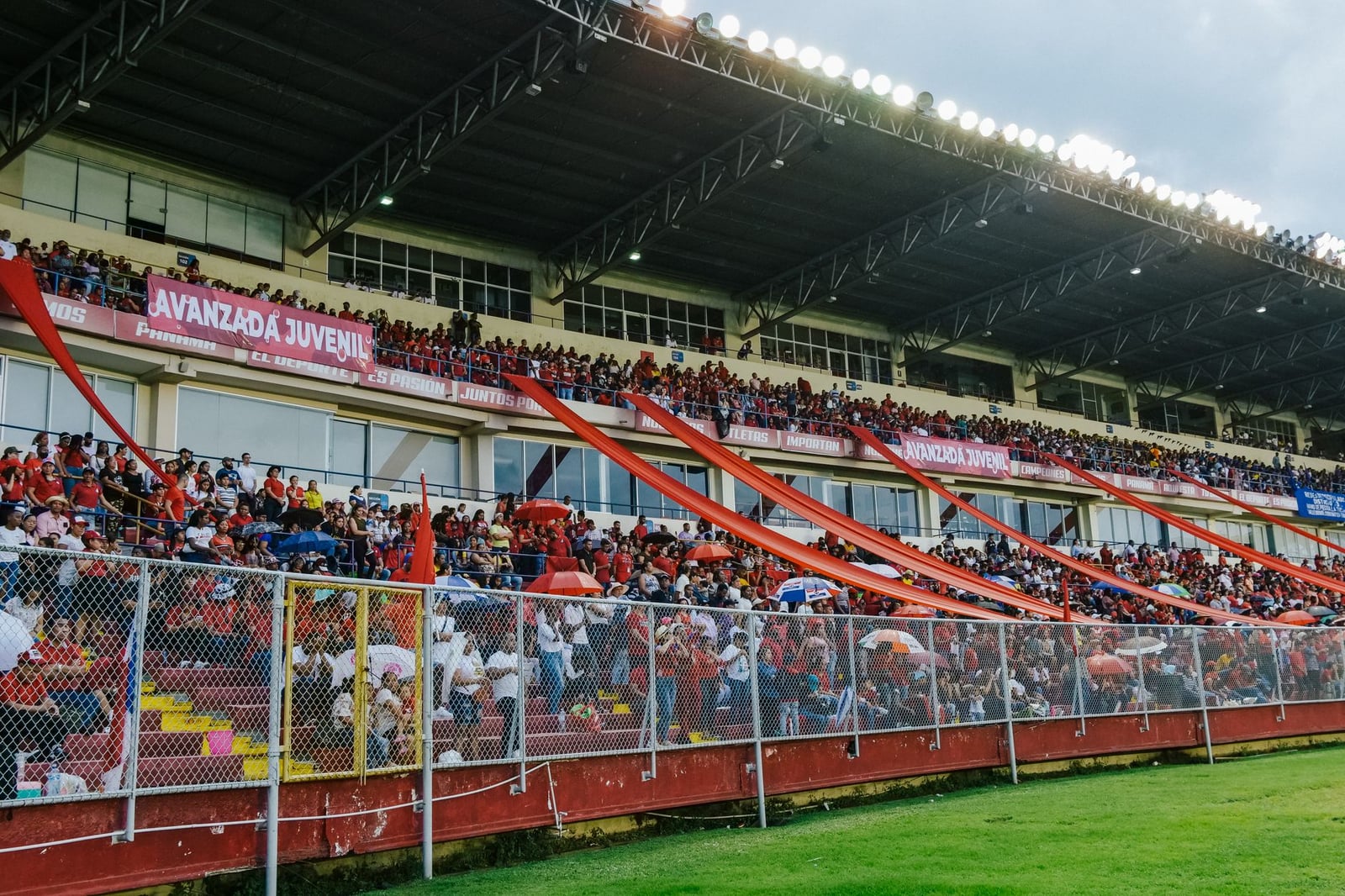 Un estadio vibrante lleno de apasionados aficionados al deporte ondeando pancartas y animando.