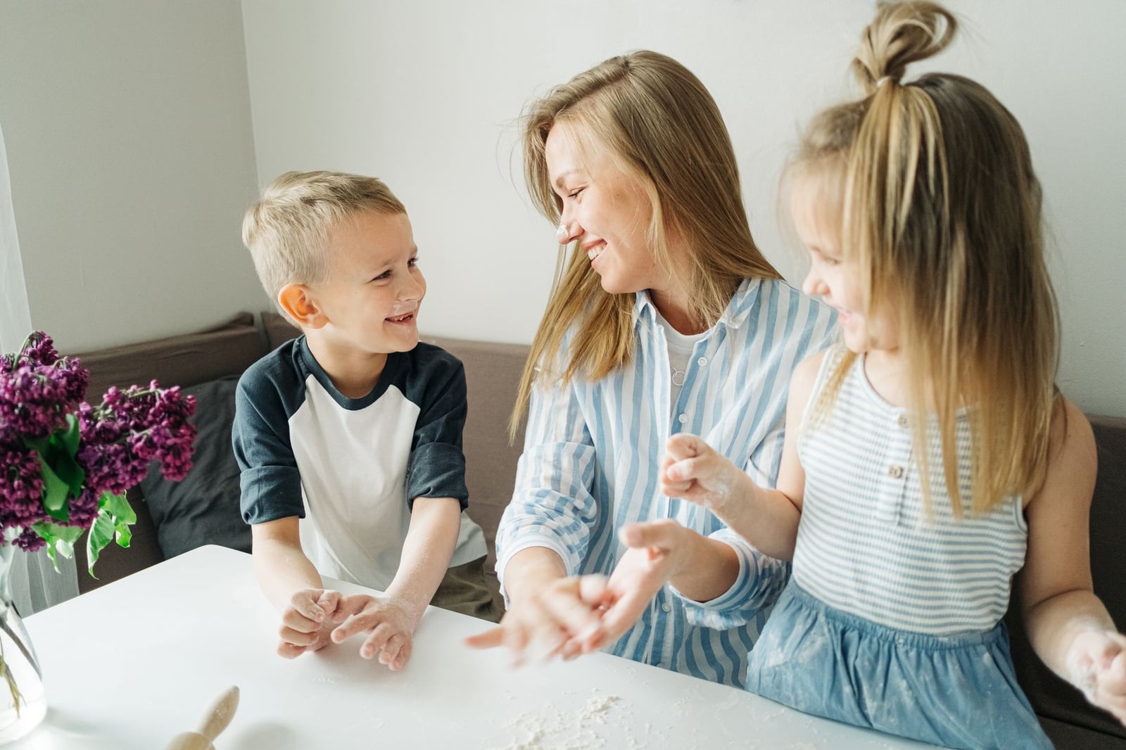 Una madre y sus dos hijos disfrutan de una divertida sesión de repostería en casa.