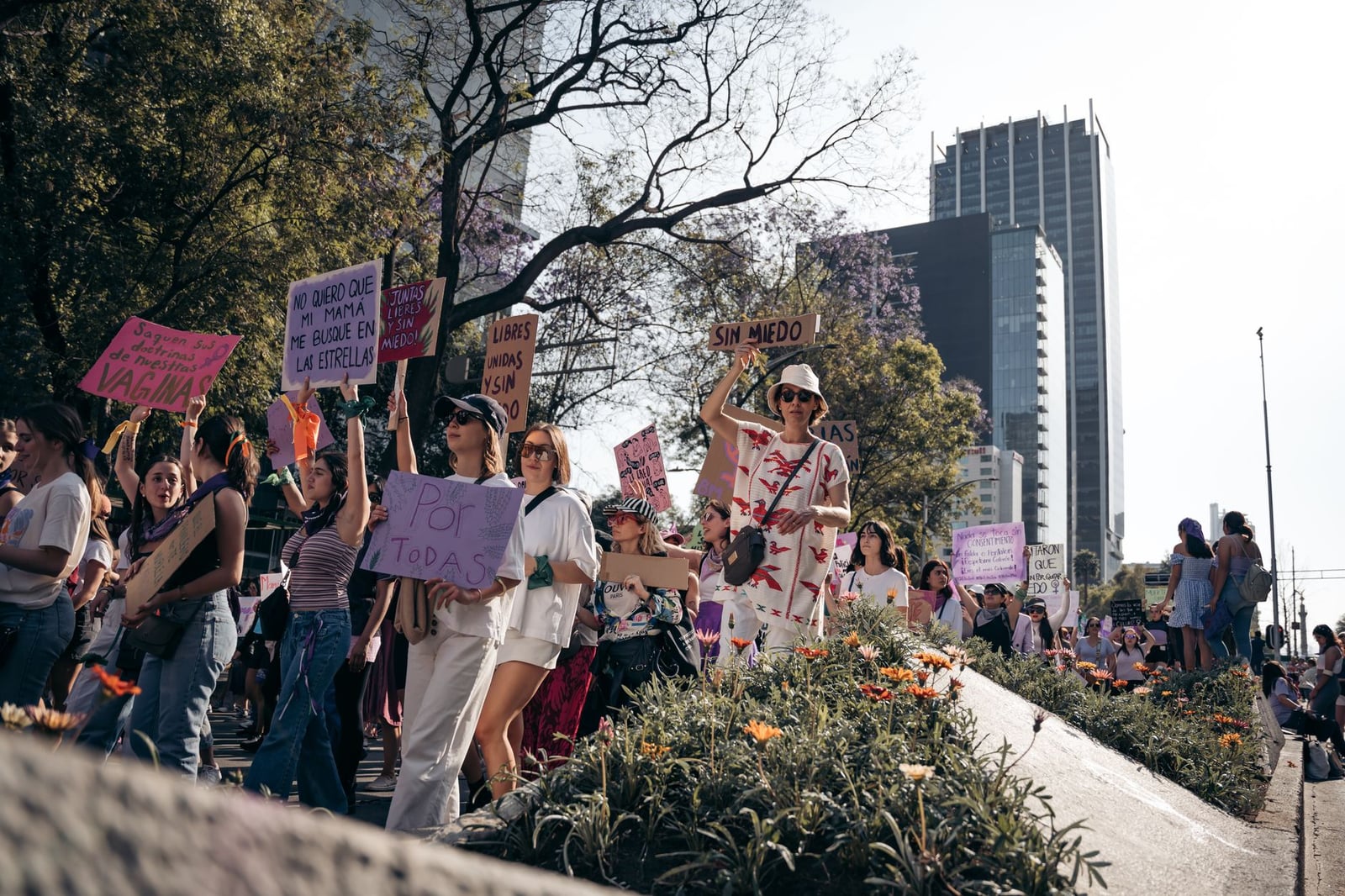 Protesta por los derechos de las mujeres en la Ciudad de México con participantes diversos y pancartas coloridas.