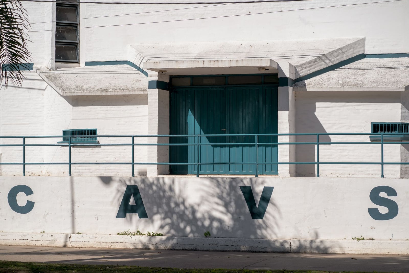 Vista exterior de un edificio de un club deportivo en Oliva, Córdoba, Argentina, con las letras CAVS en la pared.