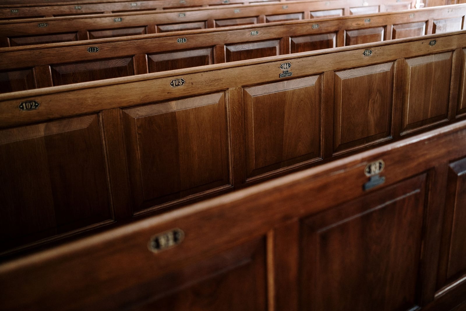 Vista en primer plano de bancos de madera dentro de una iglesia, mostrando el diseño intrincado.