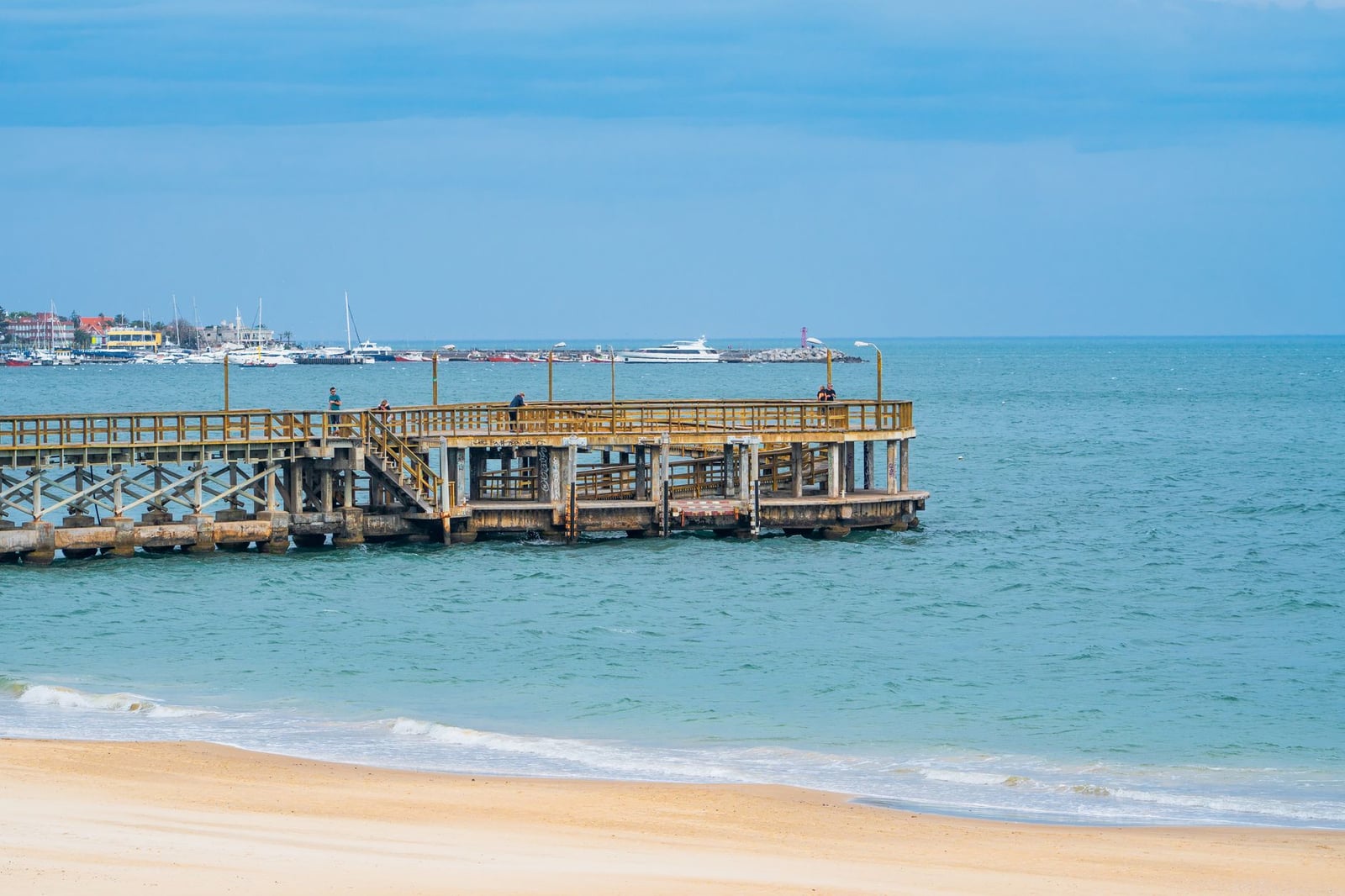 Vista tranquila de un muelle de madera y playa en Punta del Este, Uruguay en un día soleado.