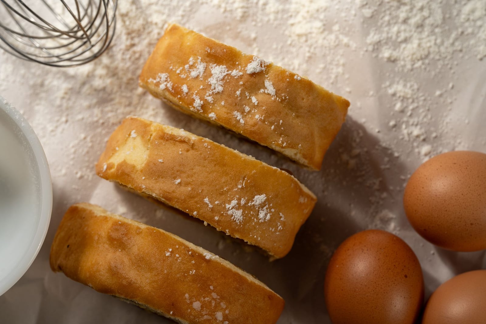 Primer plano de rebanadas de pastel fresco con huevos y harina, perfecto para temas de repostería.