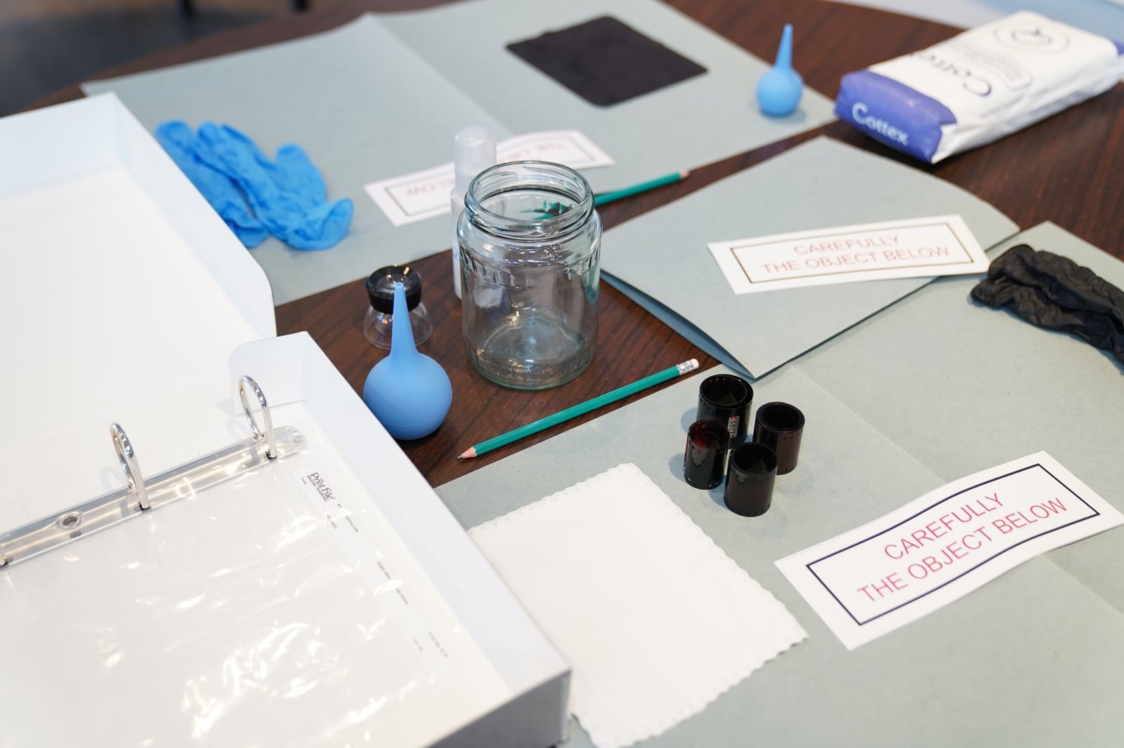 Herramientas forenses organizadas, incluidos guantes y frascos, sobre una mesa para su investigación.