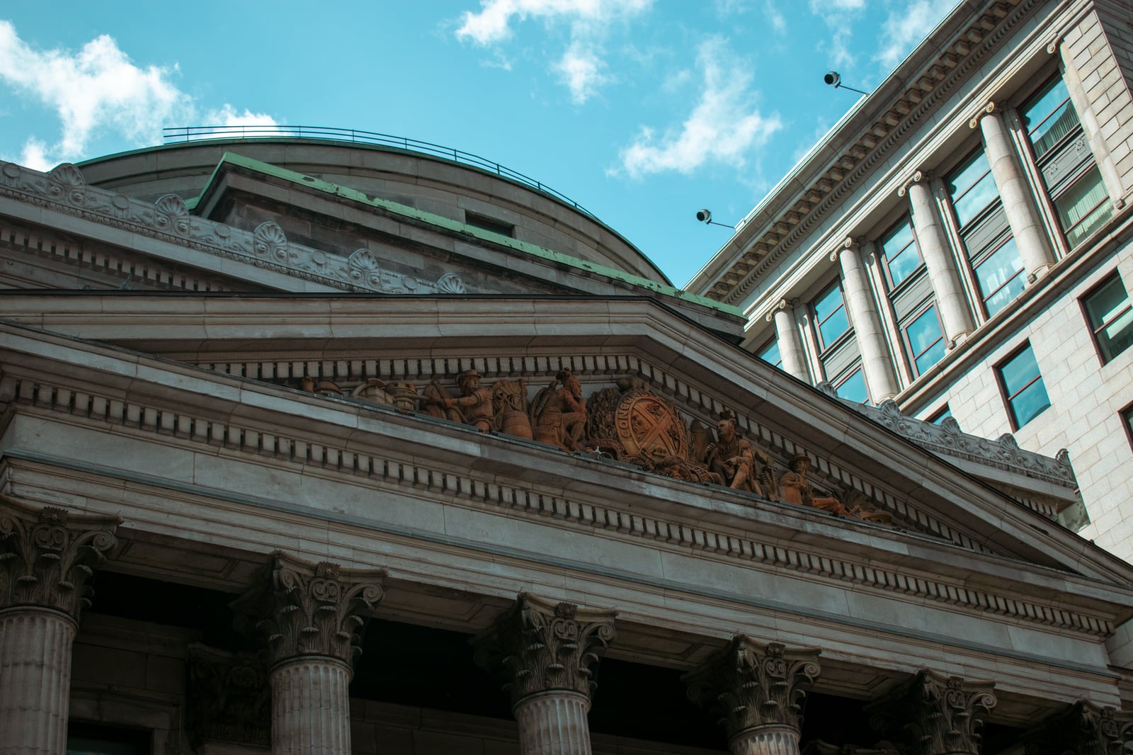 Imponente fachada de edificio neoclásico en Montreal, que muestra columnas y detalles arquitectónicos.