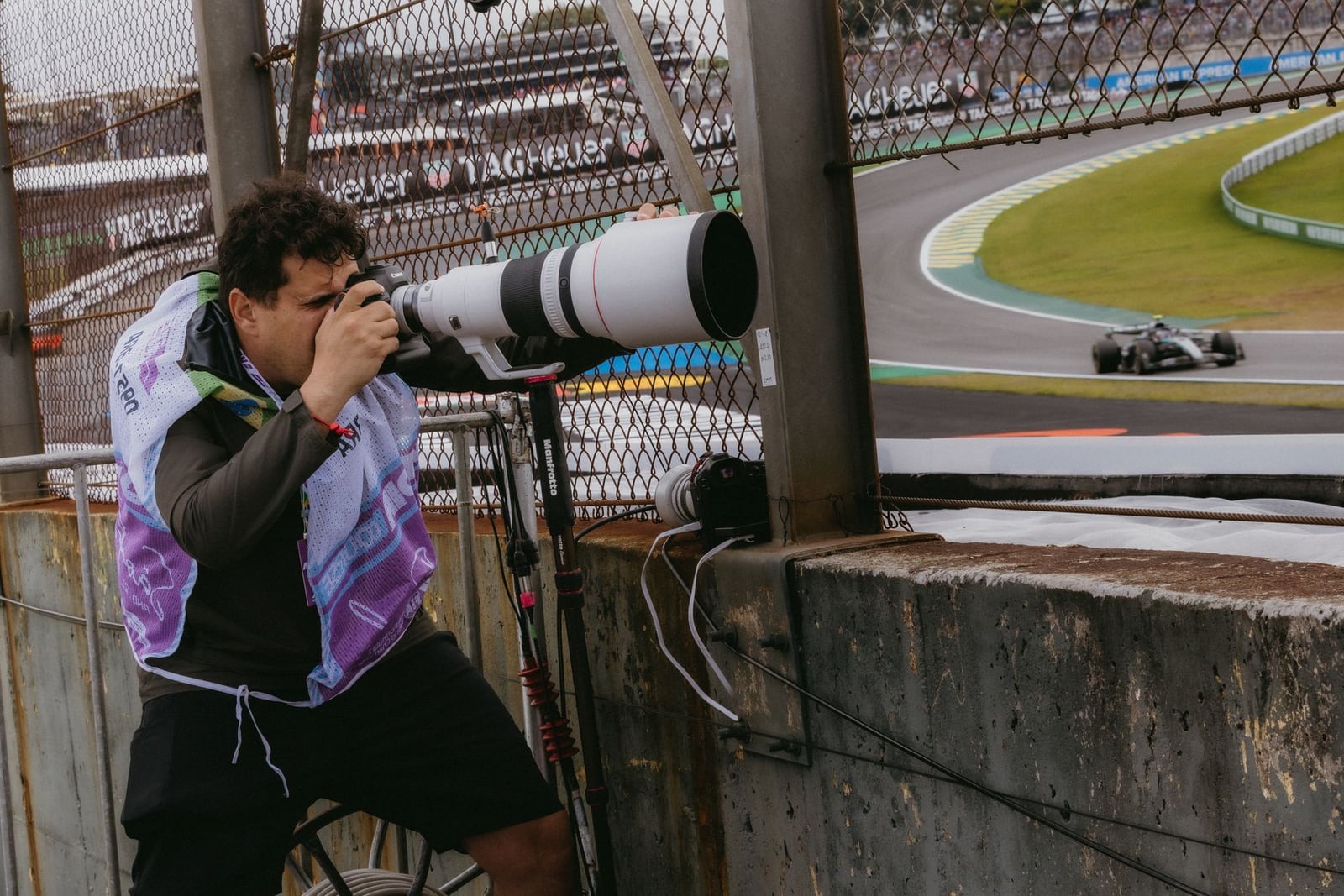 Fotógrafo deportivo en acción durante una carrera de Fórmula 1 en São Paulo, Brasil.