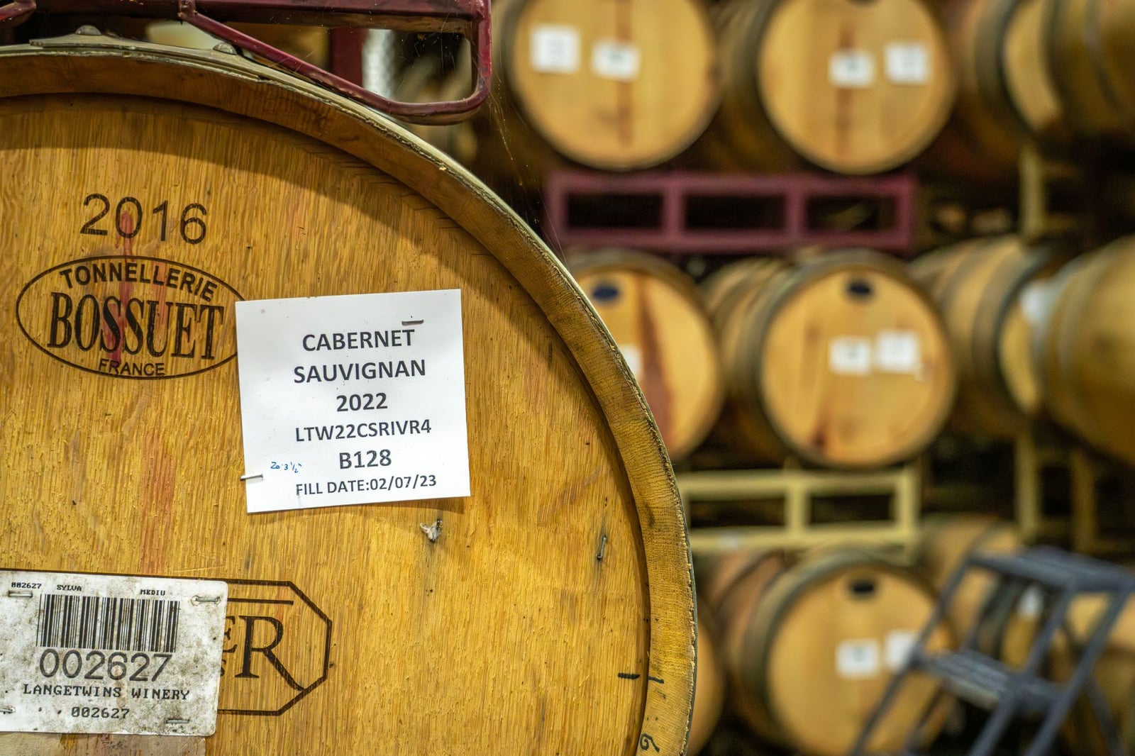 Una bodega rústica llena de barricas de Cabernet Sauvignon, mostrando un encanto vintage.