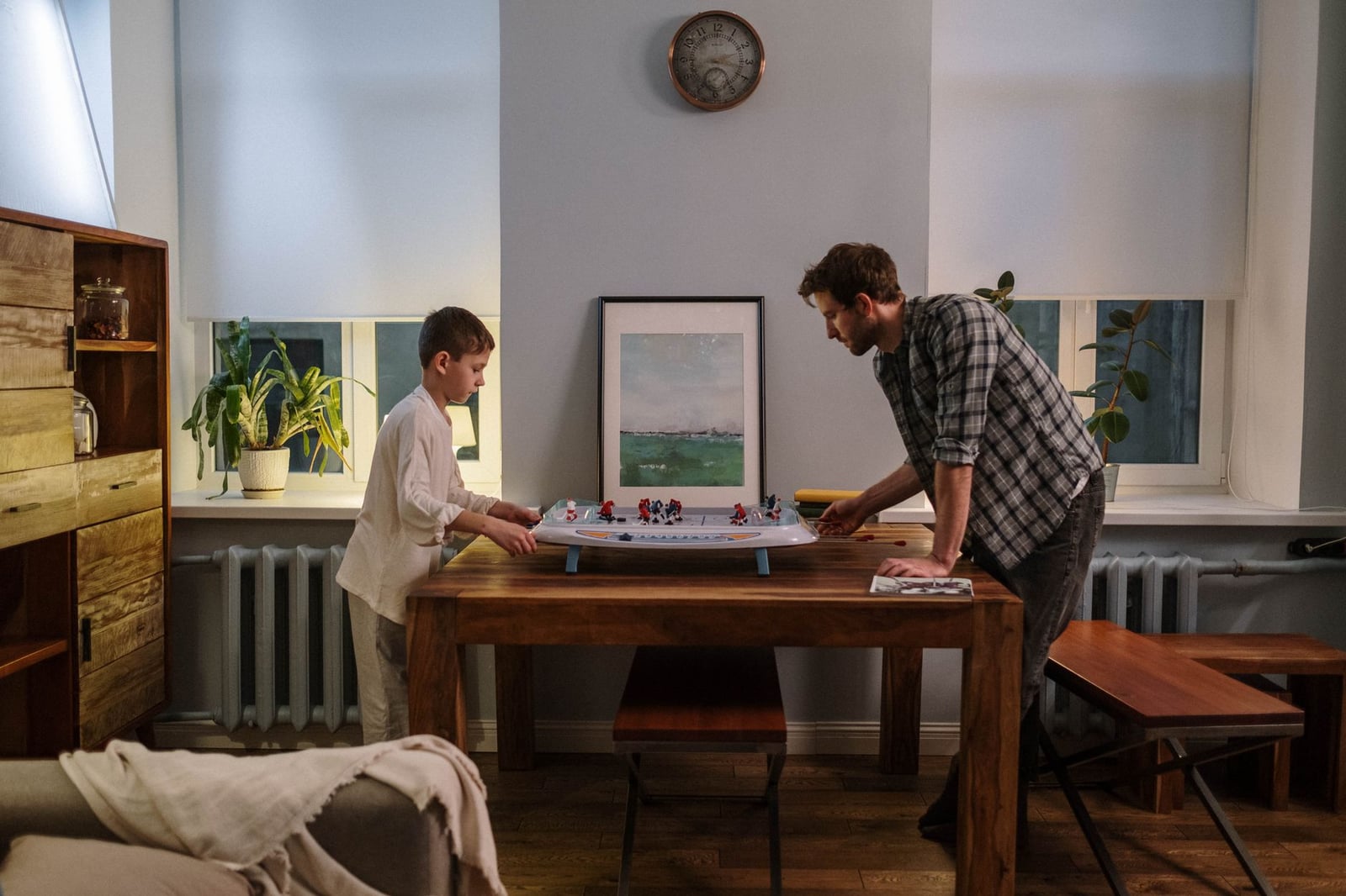 Padre e hijo disfrutan de un juego de hockey de mesa juntos en un acogedor salón.