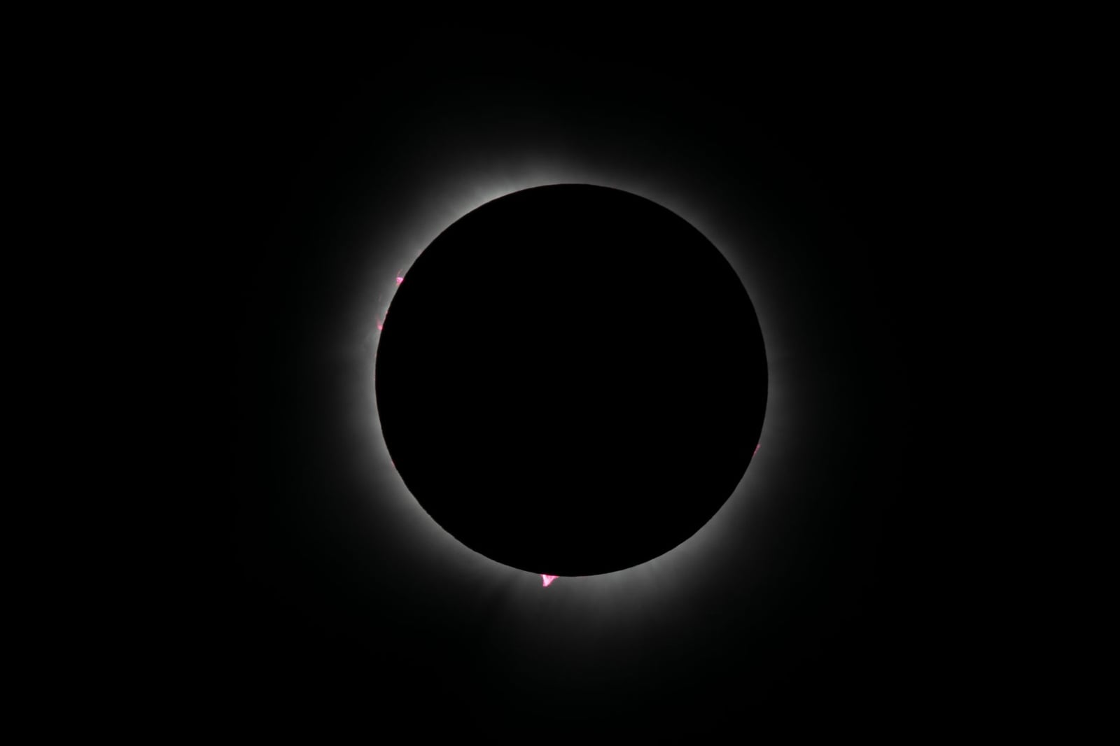 Captura de un eclipse solar anular con corona resplandeciente, mostrando la belleza celestial en un cielo oscuro.