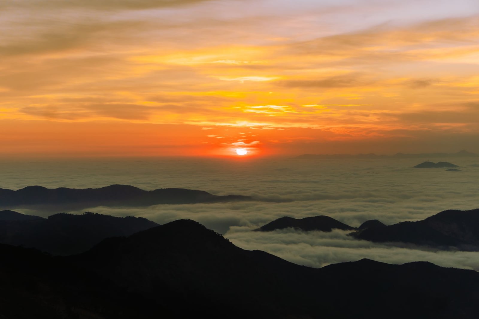 Captura de un impresionante atardecer sobre cumbres de montaña con nubes en Pinal de Amoles, México.