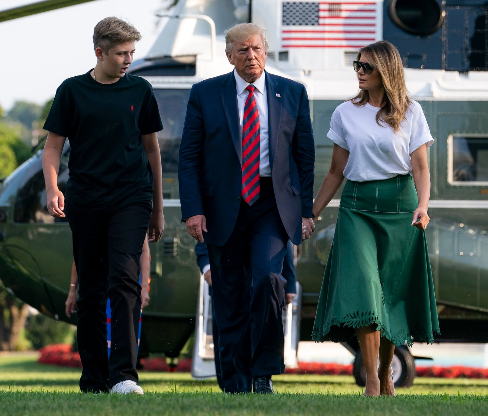 President Donald J. Trump, First Lady Melania Trump, and their son, Barron, walk across the South Lawn of the White House Sunday, August 18, 2019, following their stay in Bedminster, New Jersey. (Offi