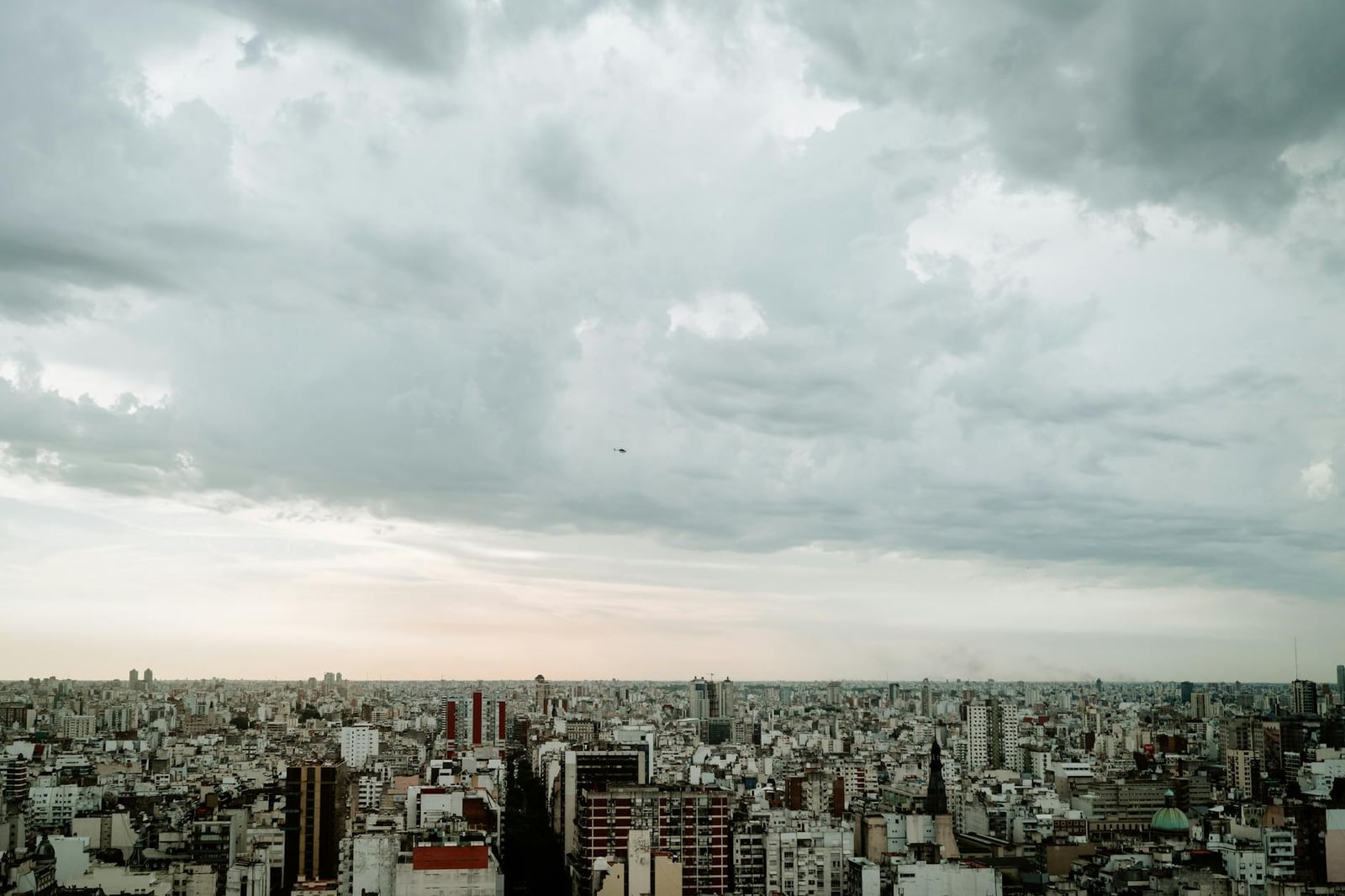 Una vista aérea panorámica del horizonte de Buenos Aires bajo un cielo nublado, enfatizando la densidad urbana.