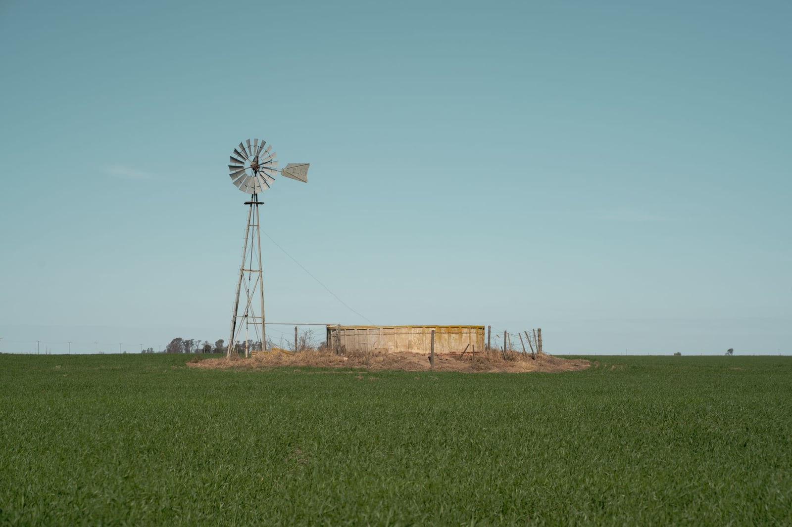 Un paisaje tranquilo con un molino de viento y vegetación en Córdoba, Argentina.