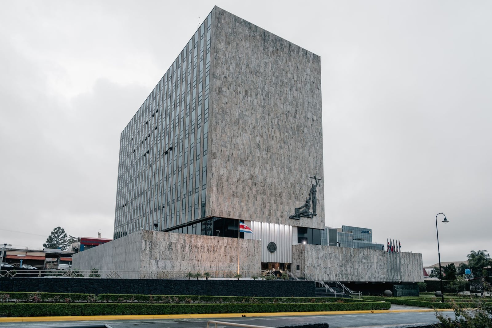Fotografía arquitectónica del edificio de la Corte Suprema en San José, Costa Rica, que destaca por su diseño moderno y las banderas nacionales.