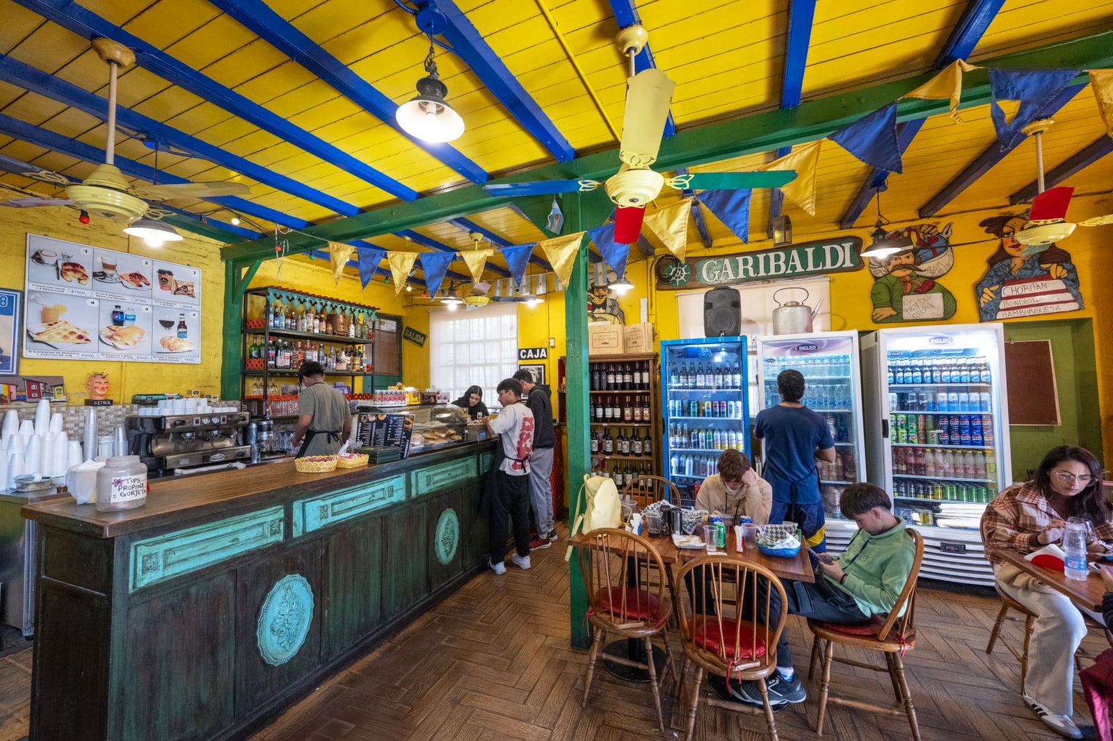 Vibrante escena de cafés en Buenos Aires con gente disfrutando del tiempo libre y una decoración colorida.