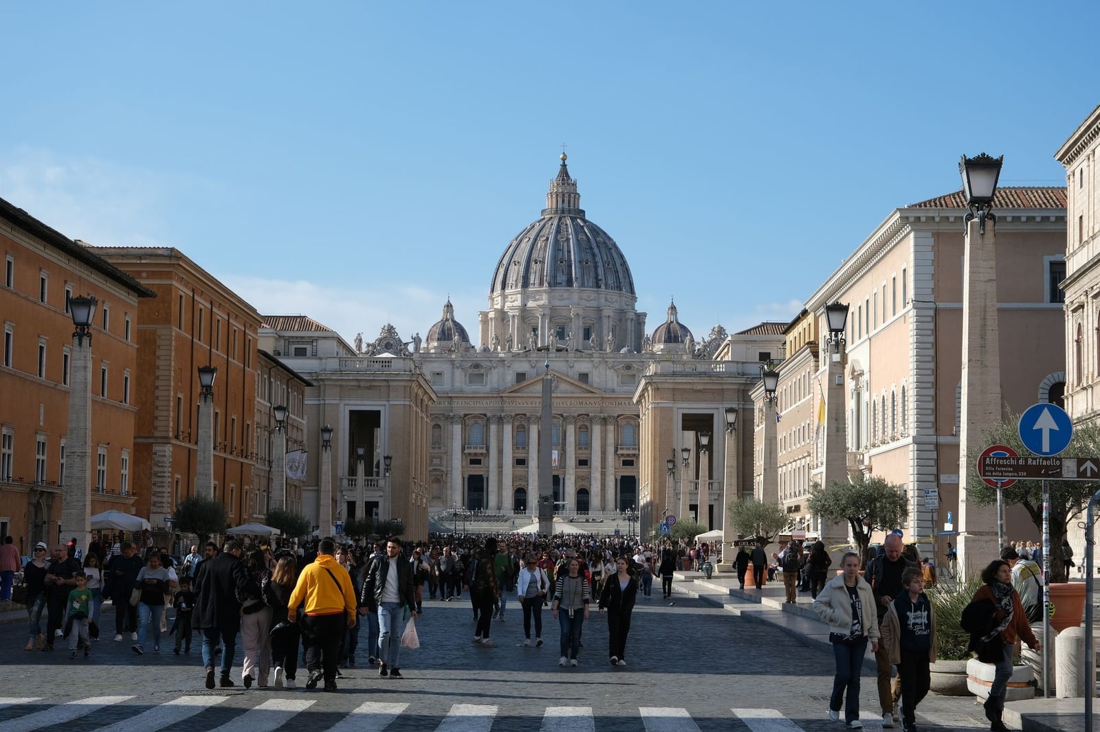Multitudes se reúnen en la Basílica de San Pedro, un símbolo de la Ciudad del Vaticano, bajo el cielo diurno.