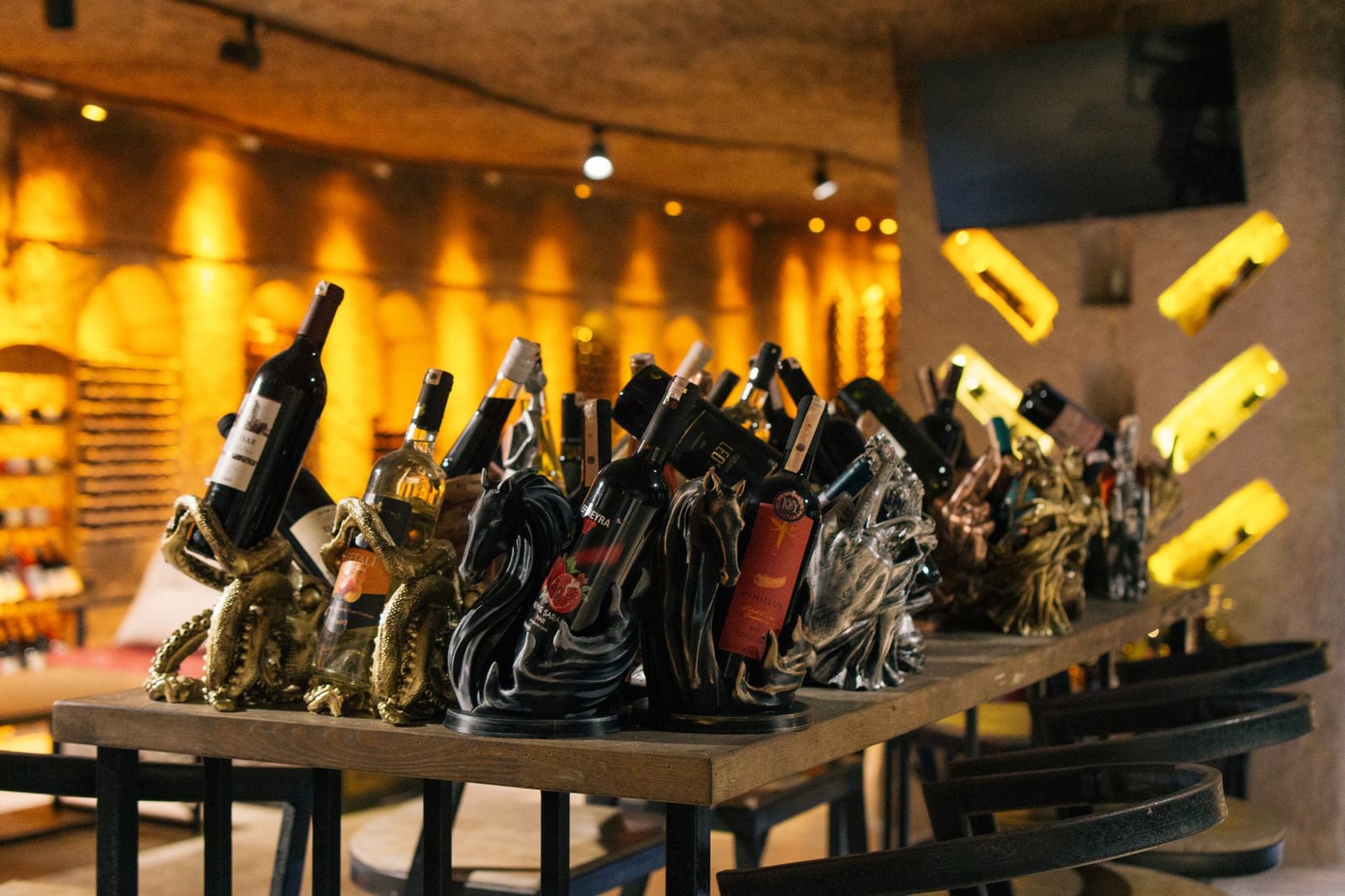 Elegantes botellas de vino expuestas con distinción en un entorno de bodega turca moderna, creando un ambiente cálido.