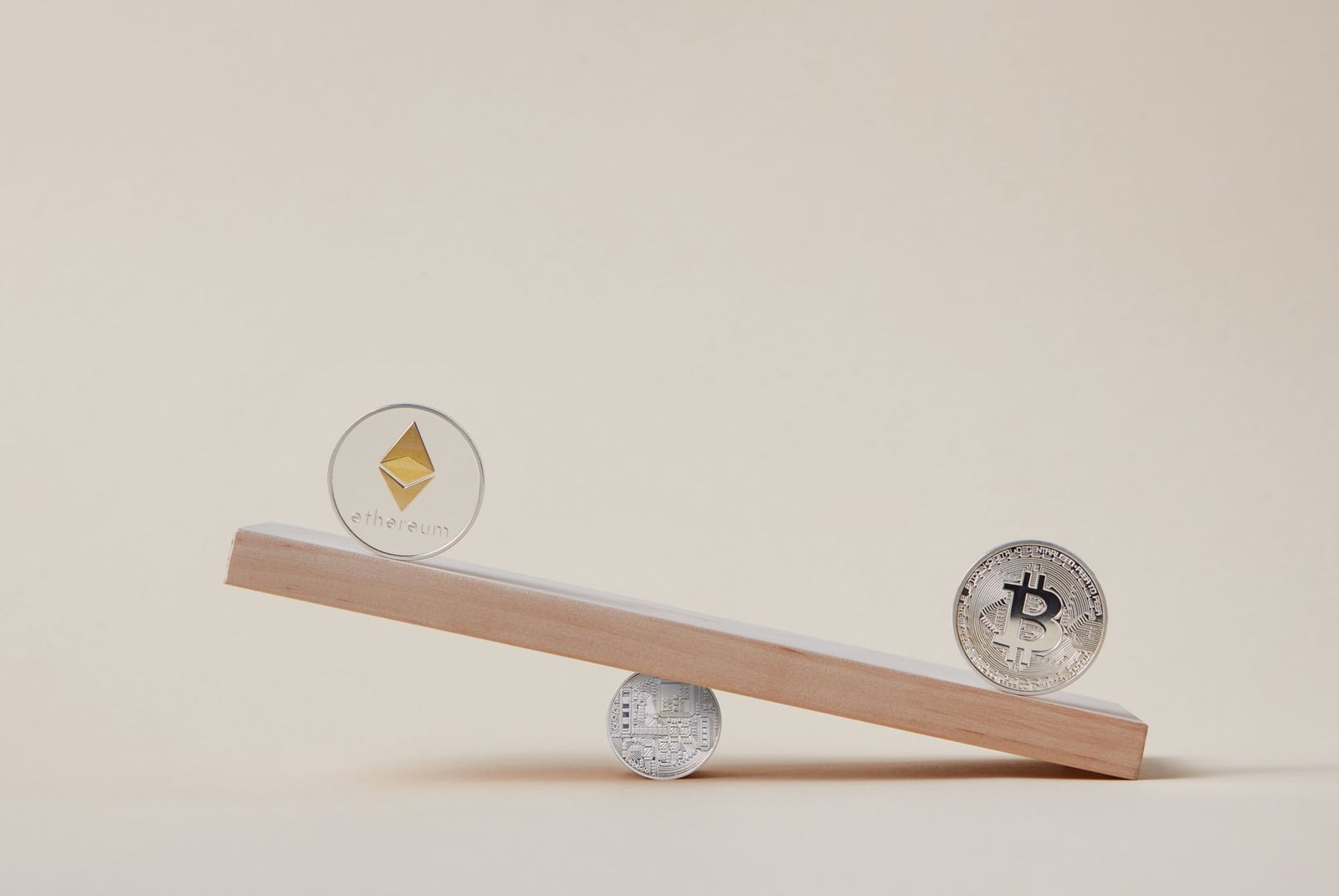Imagen minimalista de monedas de Ethereum y Bitcoin equilibrándose en una tabla, simbolizando la dinámica del mercado cripto.
