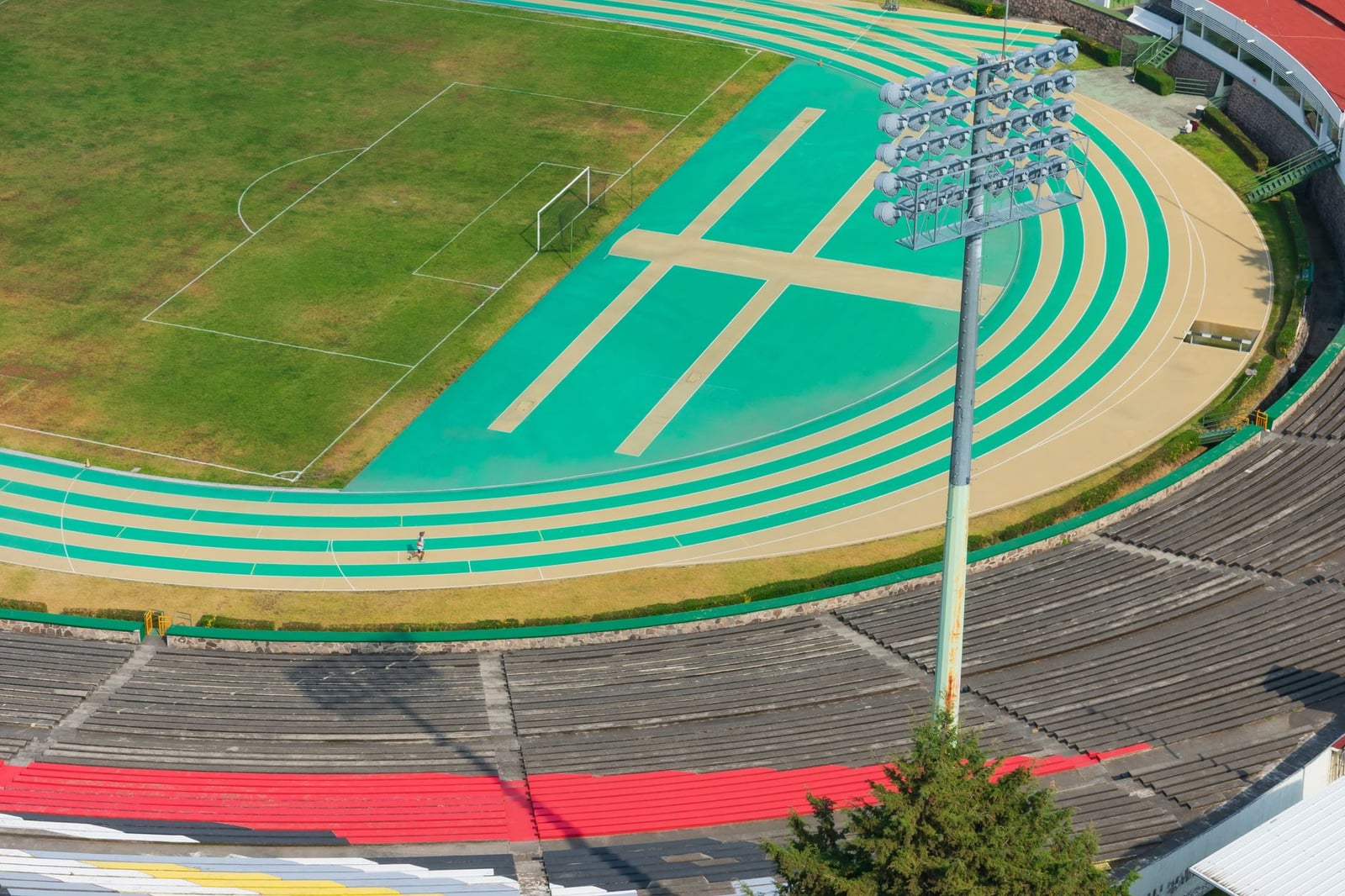 Fotografía aérea de una pista deportiva al aire libre y un estadio en Toluca de Lerdo, México, que captura colores vibrantes y diseño atlético.
