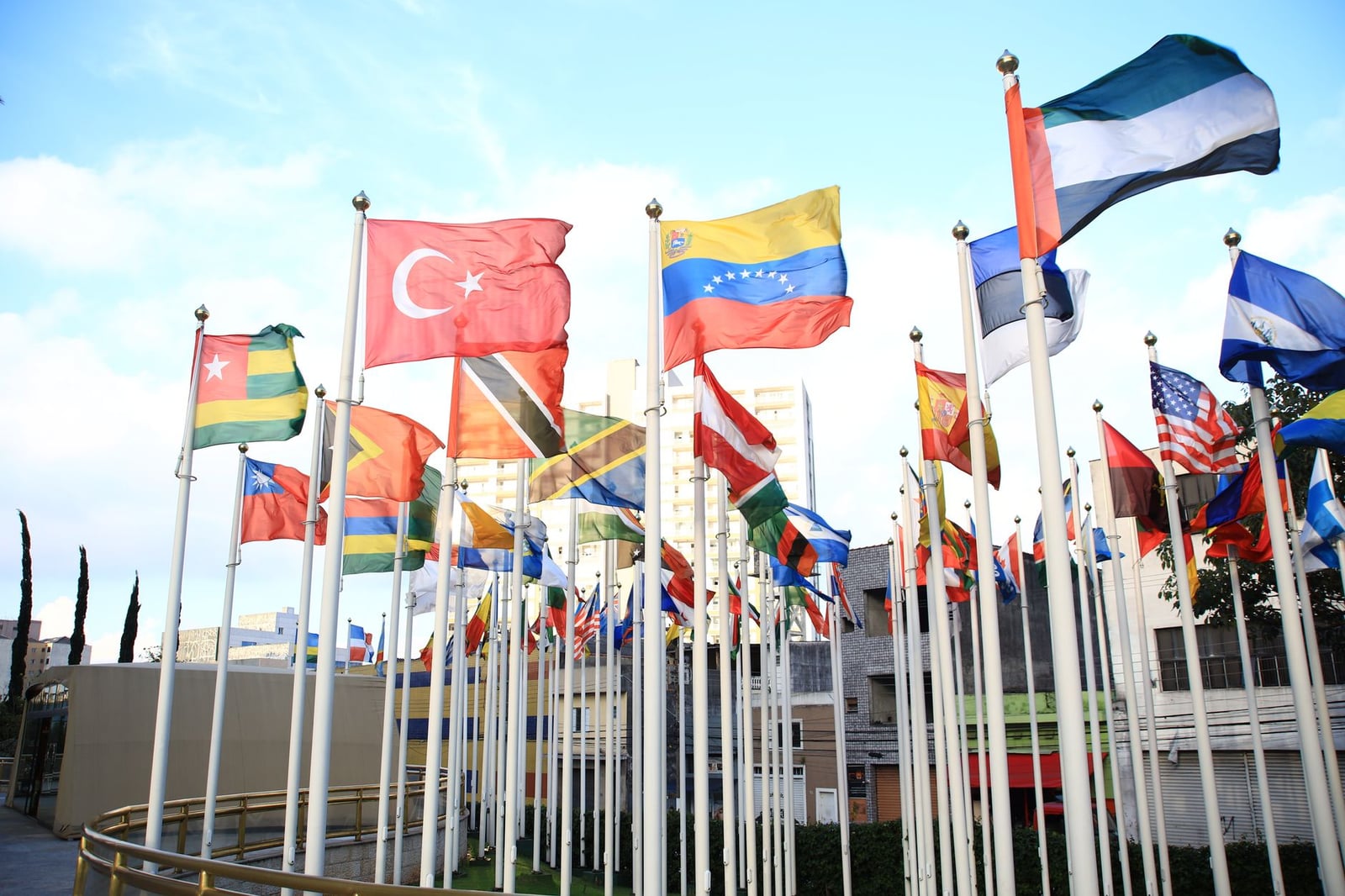 Una vibrante colección de banderas internacionales en un paisaje urbano, simbolizando la unidad global.