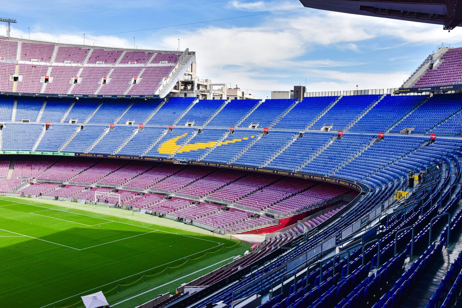 Una vista panorámica de las icónicas gradas vacías del Camp Nou, el renombrado estadio de fútbol de Barcelona bajo un cielo despejado.