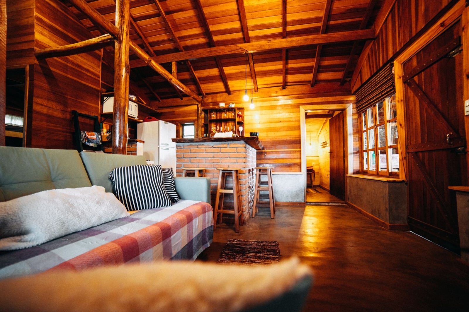 Un encantador interior rústico con vigas de madera y una iluminación cálida, perfecto para retiros acogedores.