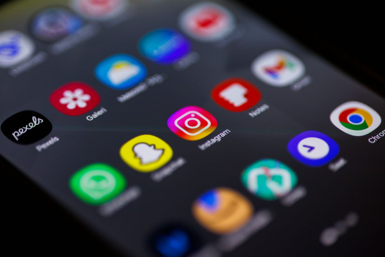 Vista de cerca de la pantalla de inicio del teléfono inteligente con aplicaciones populares como Instagram, Snapchat y Chrome.