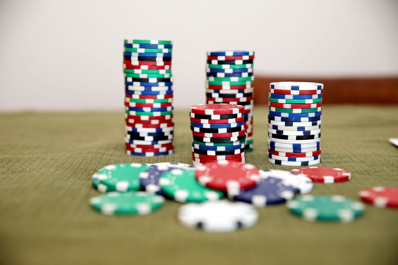 Montones de fichas de póker coloridas sobre una mesa verde listas para un juego.