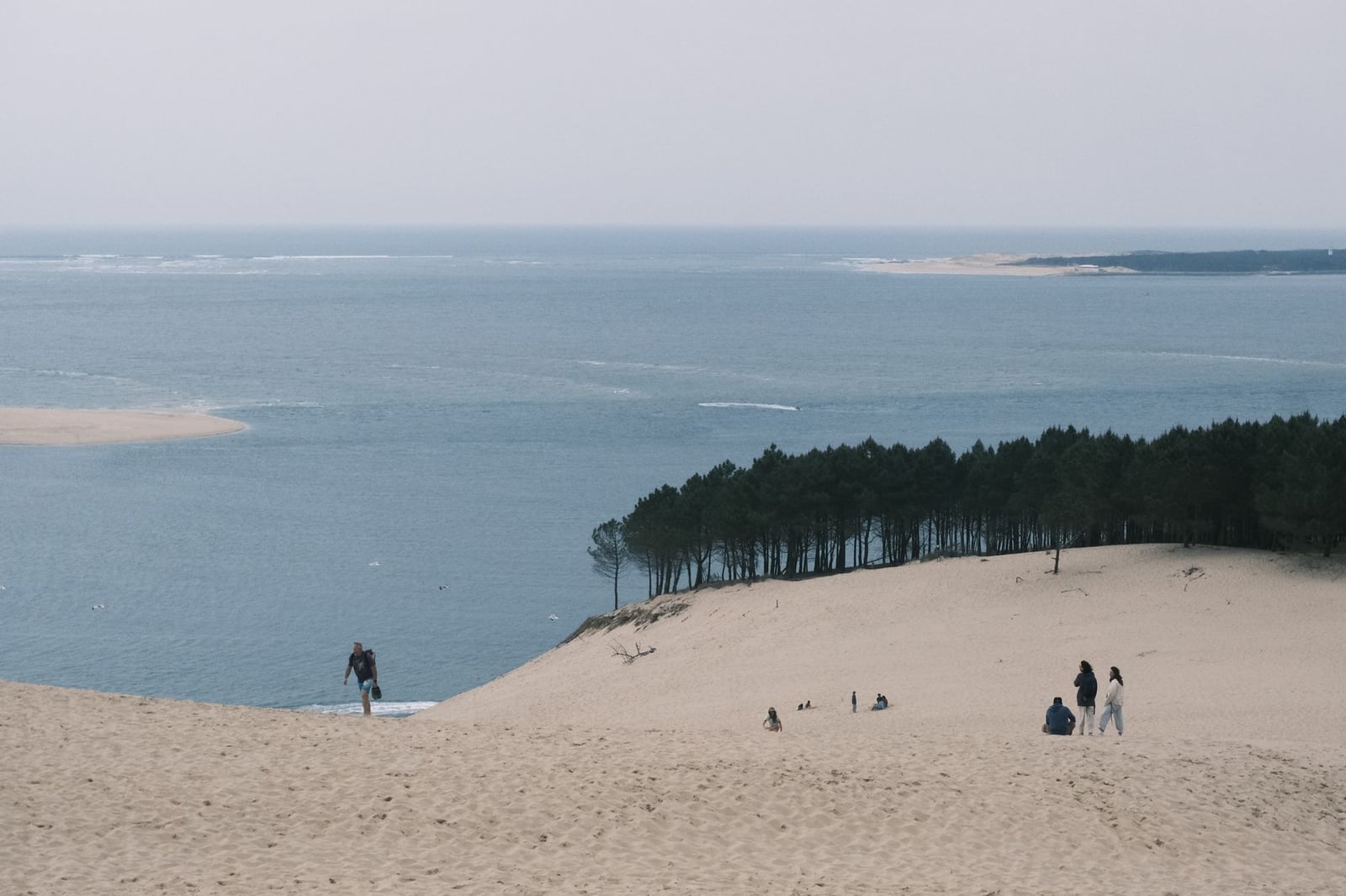 Vista serena de las dunas de arena que se encuentran con el Océano Atlántico en Nouvelle-Aquitaine, Francia.