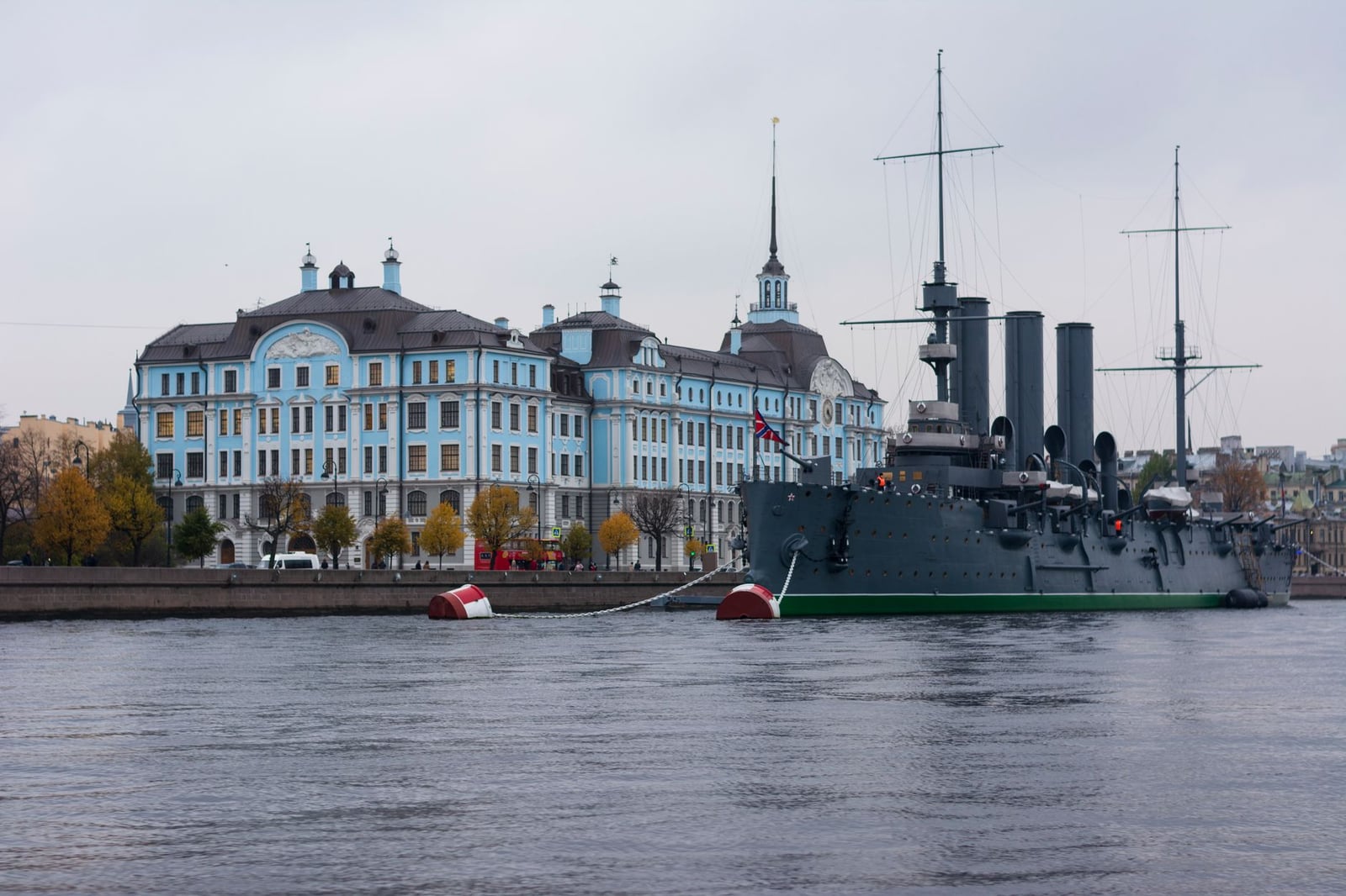 Barco histórico y edificios arquitectónicos a lo largo del Río Neva capturados en un entorno urbano sereno.