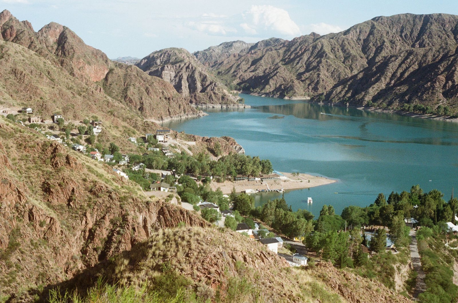 Impresionante vista aérea de un tranquilo pueblo junto al lago rodeado de montañas escarpadas.