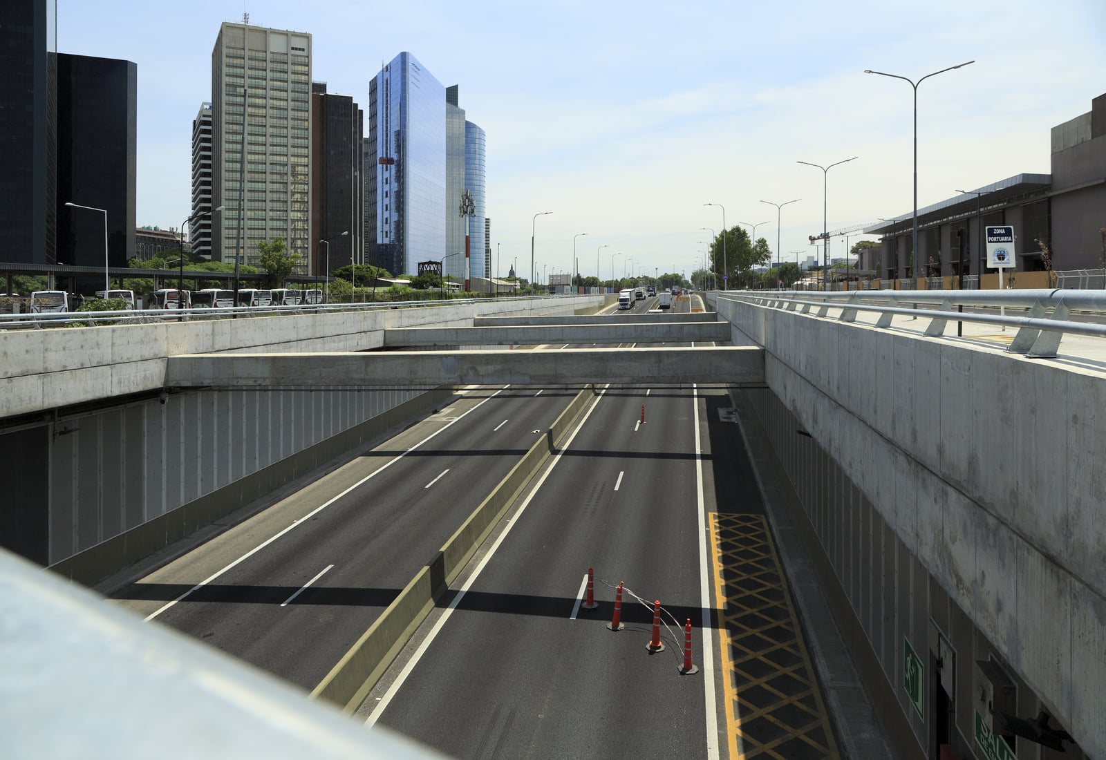 Von der Brücke der calle Cecilia Grierson Richtung Norden auf die Rampe auf Umgebungsniveau, auch hier gibt es einen Notausgang mit Halteverbot davor. Rechts liegen die Landanlagen von Buquebus und li