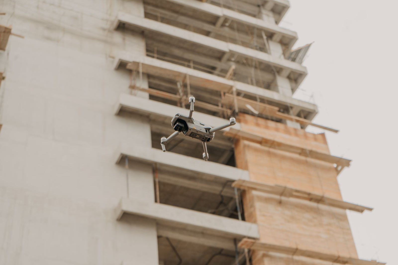 Drone aéreo en vuelo cerca de un sitio de construcción en Guatemala urbana.