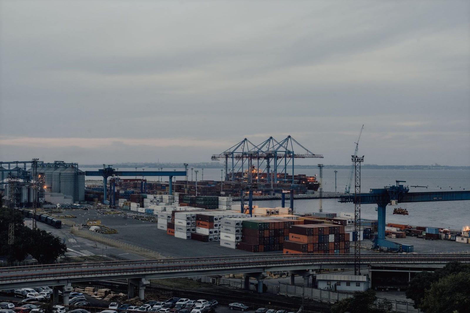 Vista aérea del puerto de Odesa, que muestra grúas, contenedores y actividad industrial al atardecer.