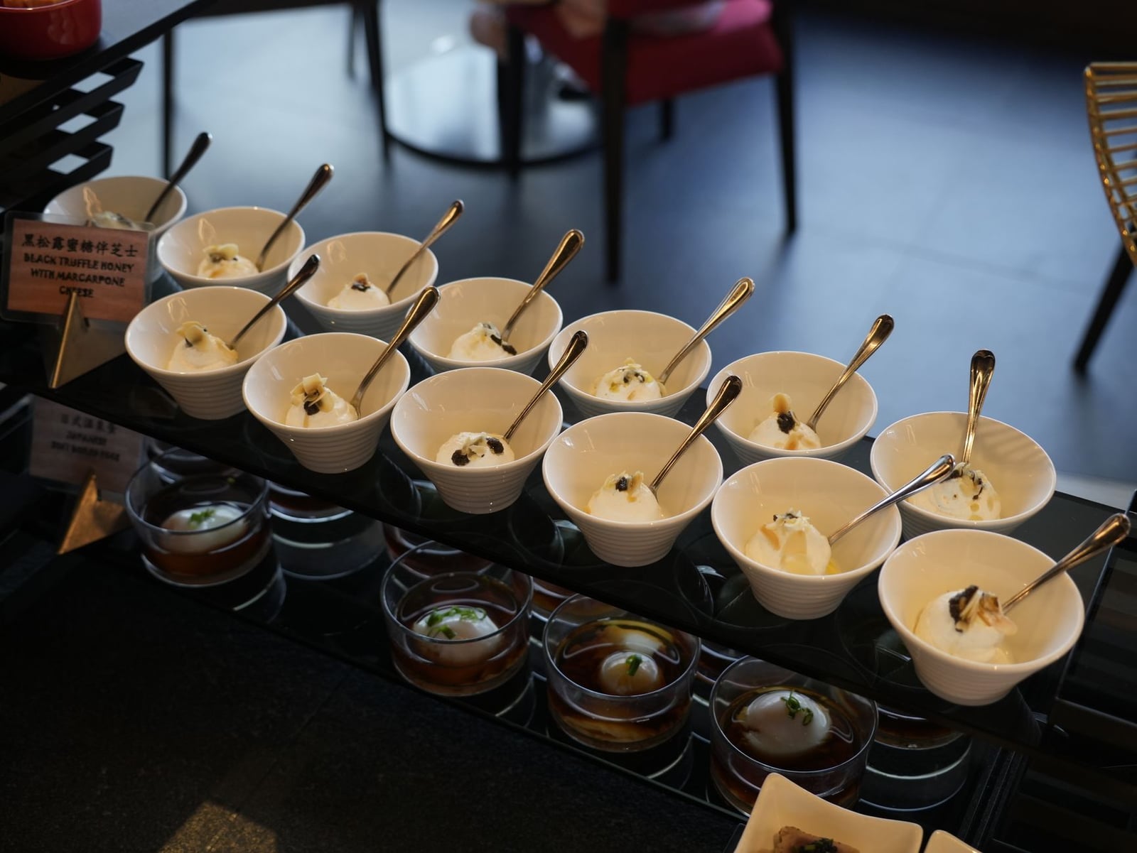 Exquisita presentación de postres de miel de trufa negra con queso mascarpone elegantemente dispuestos en cuencos.
