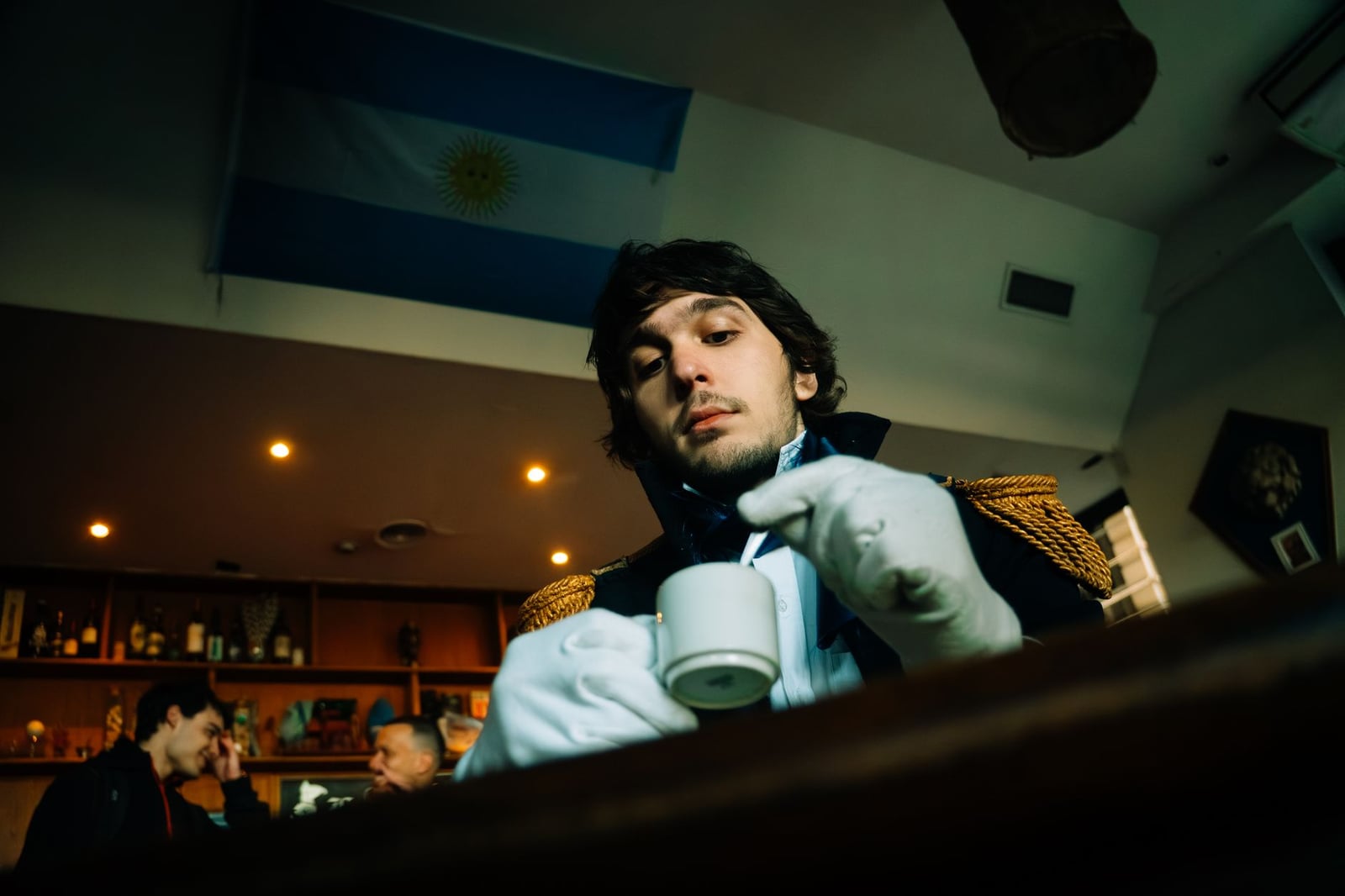 Un hombre vestido de colonial disfrutando de un café en una elegante cafetería de Buenos Aires.