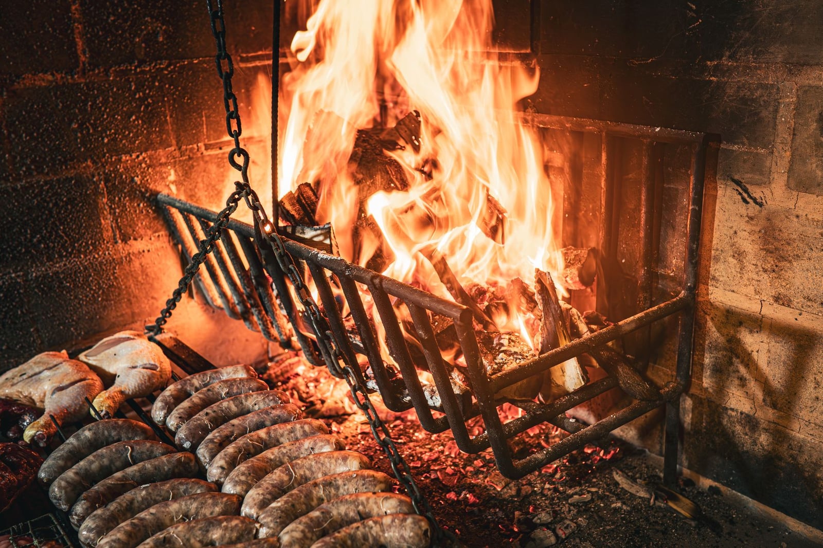 Deliciosas salchichas y pollo asándose sobre fuego de madera en Uruguayana, Brasil.