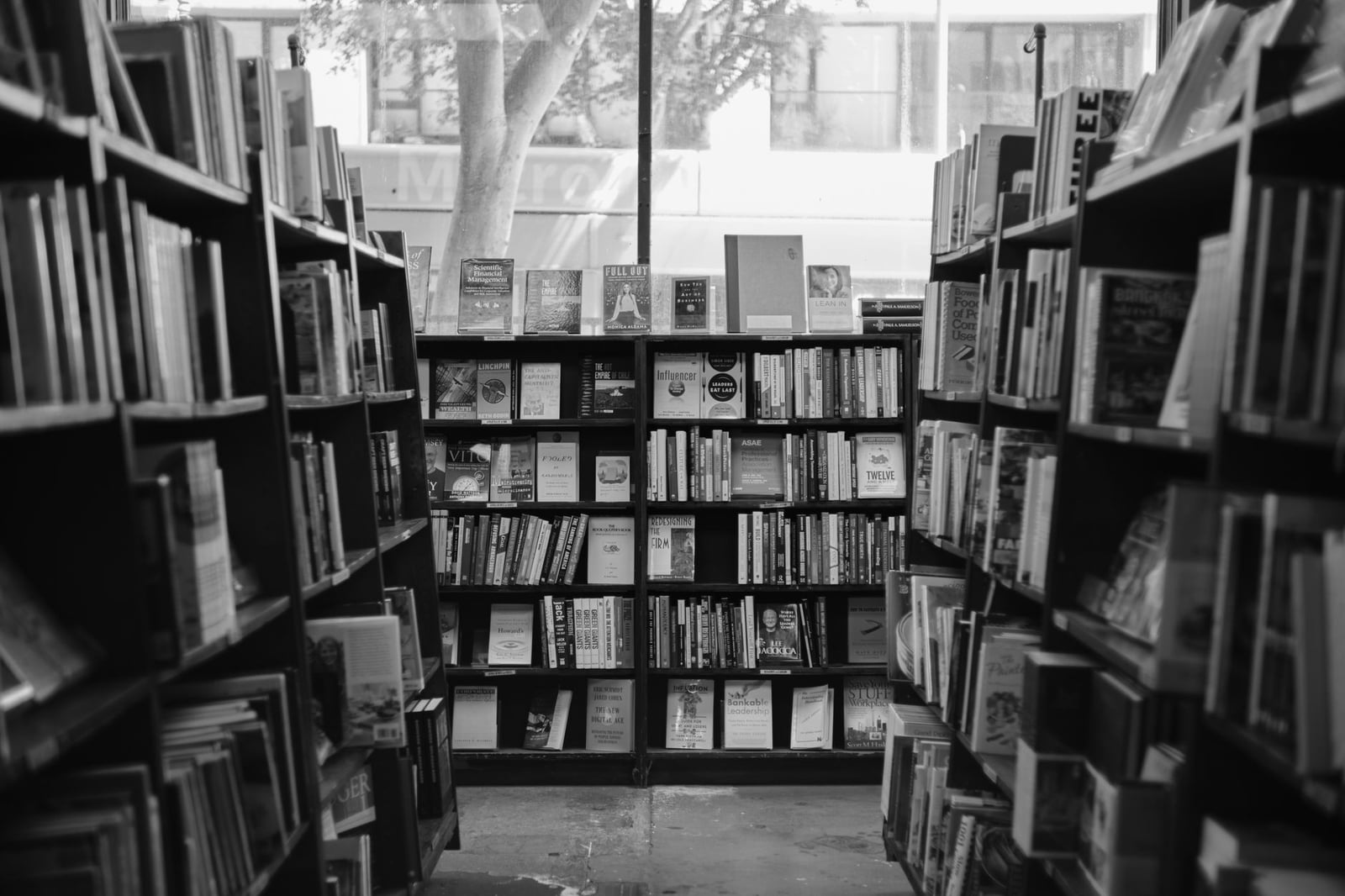 Fotografía en blanco y negro del acogedor interior de una librería con estanterías repletas de libros.